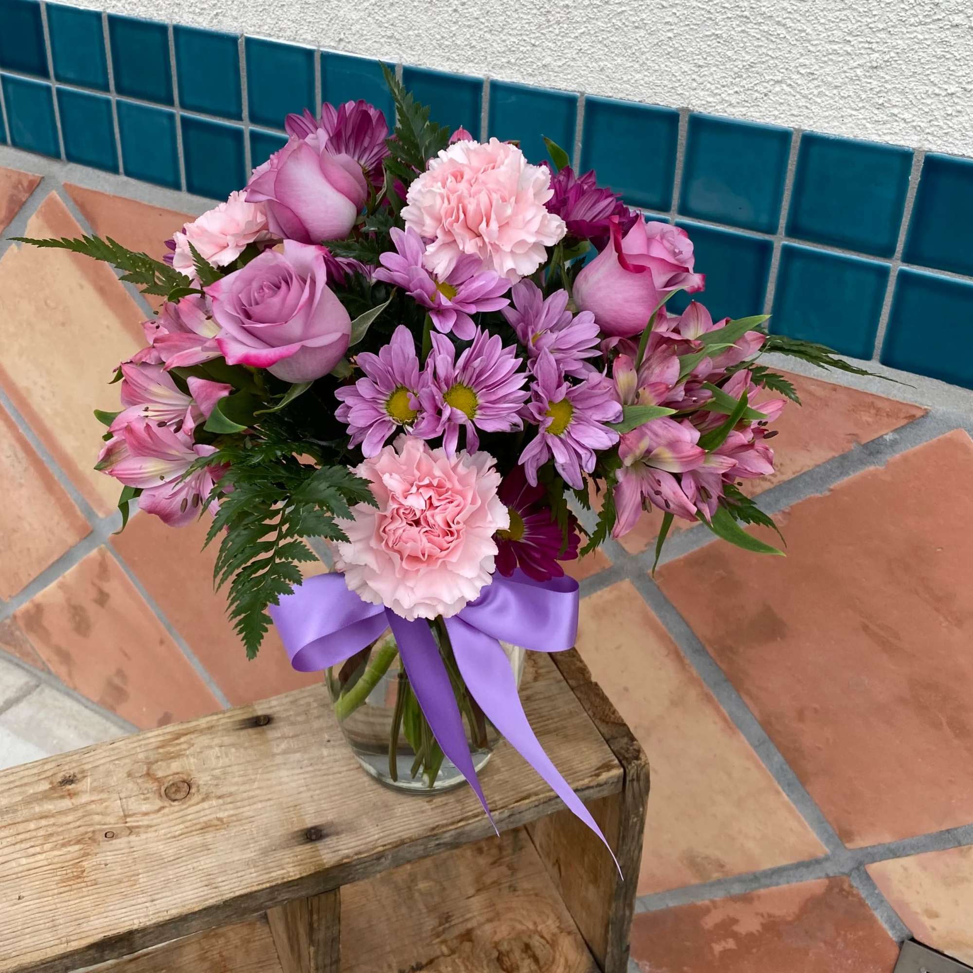 A mixed arrangement of daisy, alstromerias, roses, and carnation in pink and