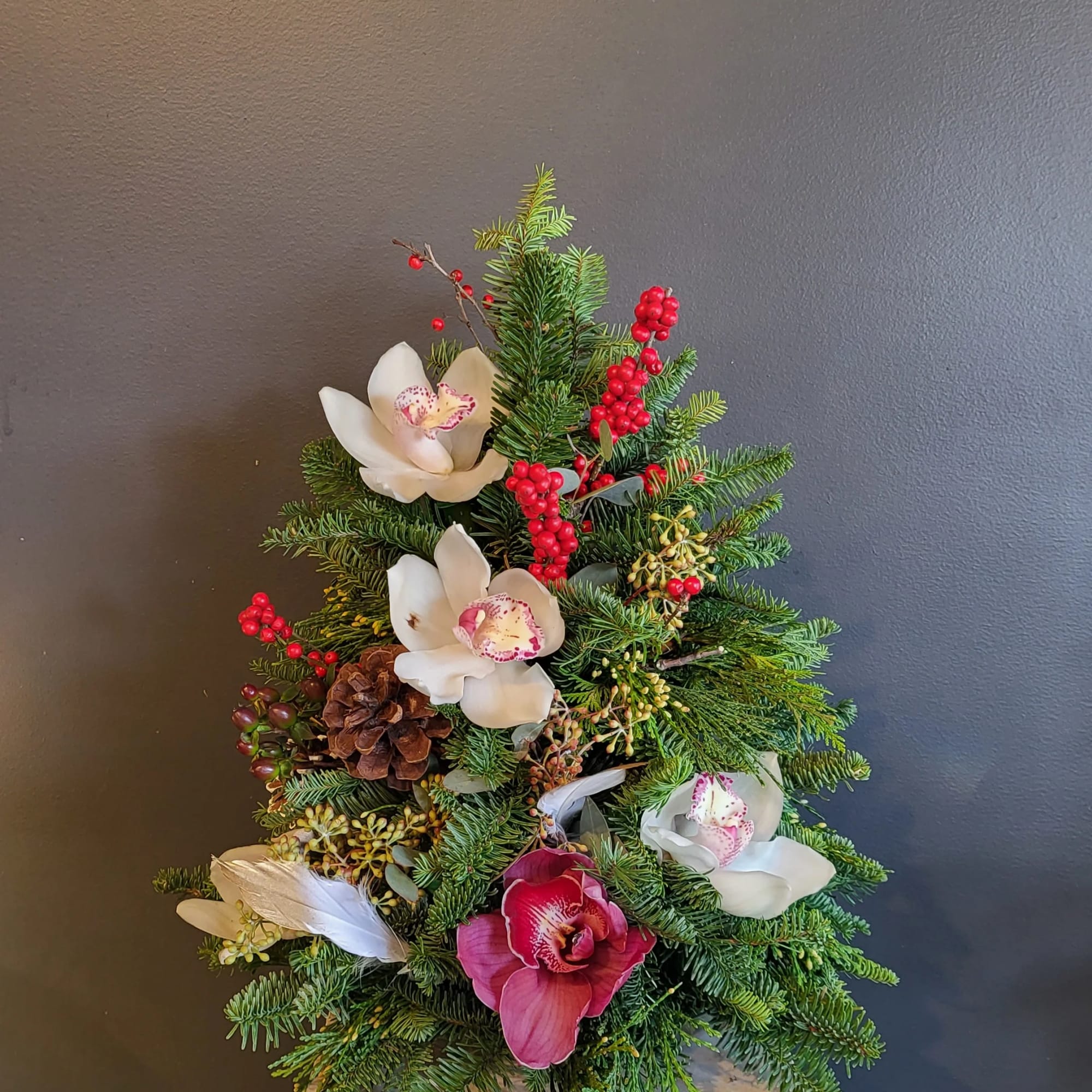 The Christmas tree and flower/berry arrangement is a festive and beautiful addition