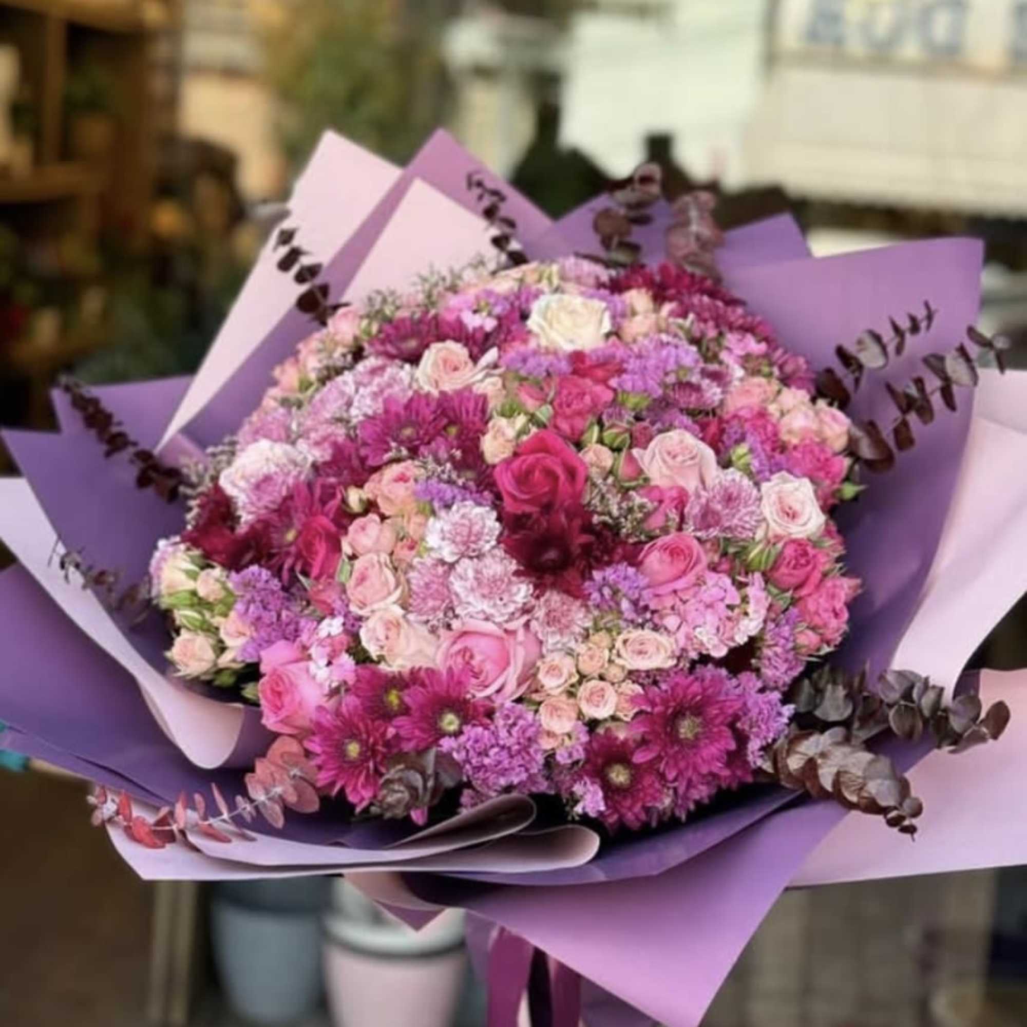This vibrant bouquet bursts with shades of pink, purple, and magenta, featuring