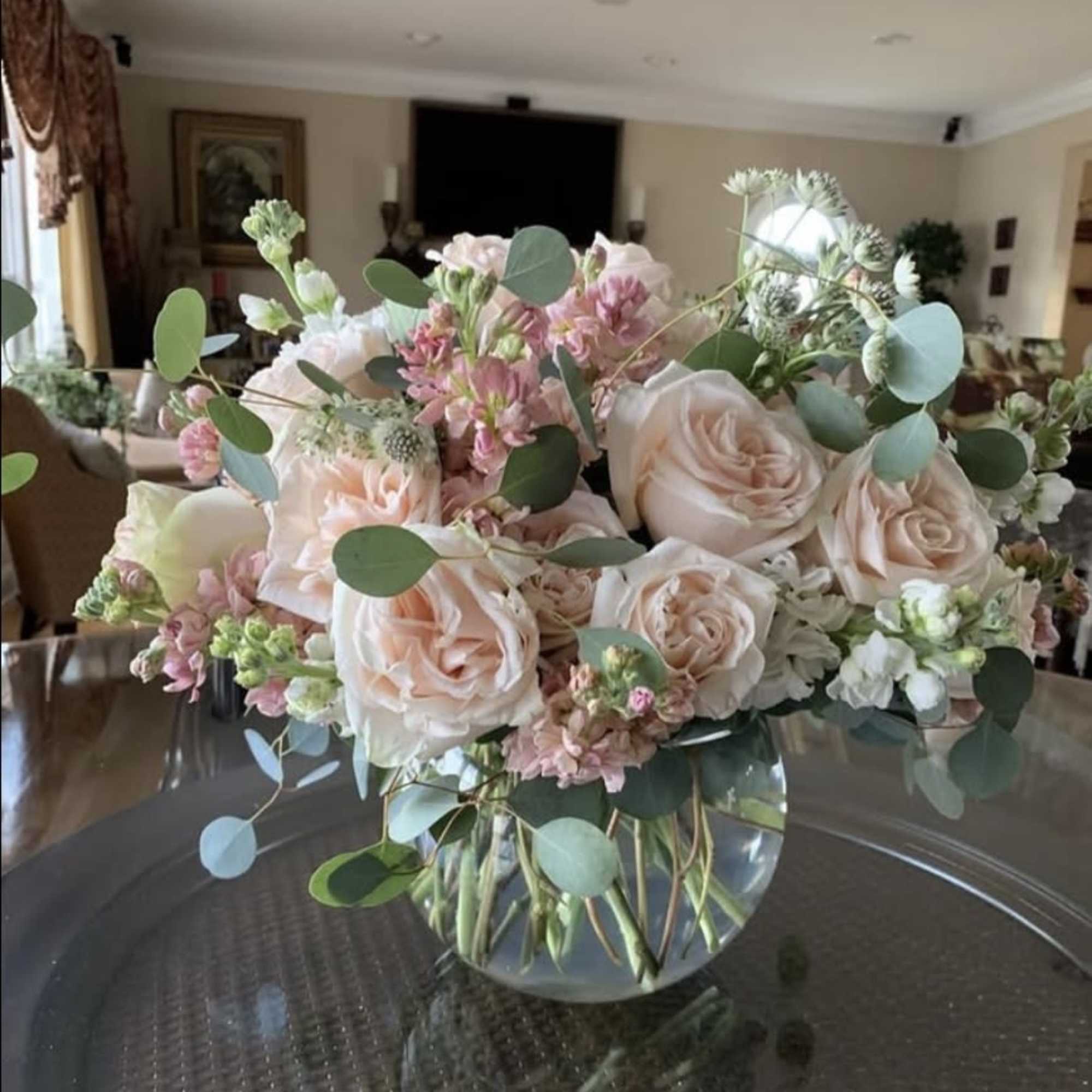 This elegant arrangement features soft blush roses, delicate pink and white stock