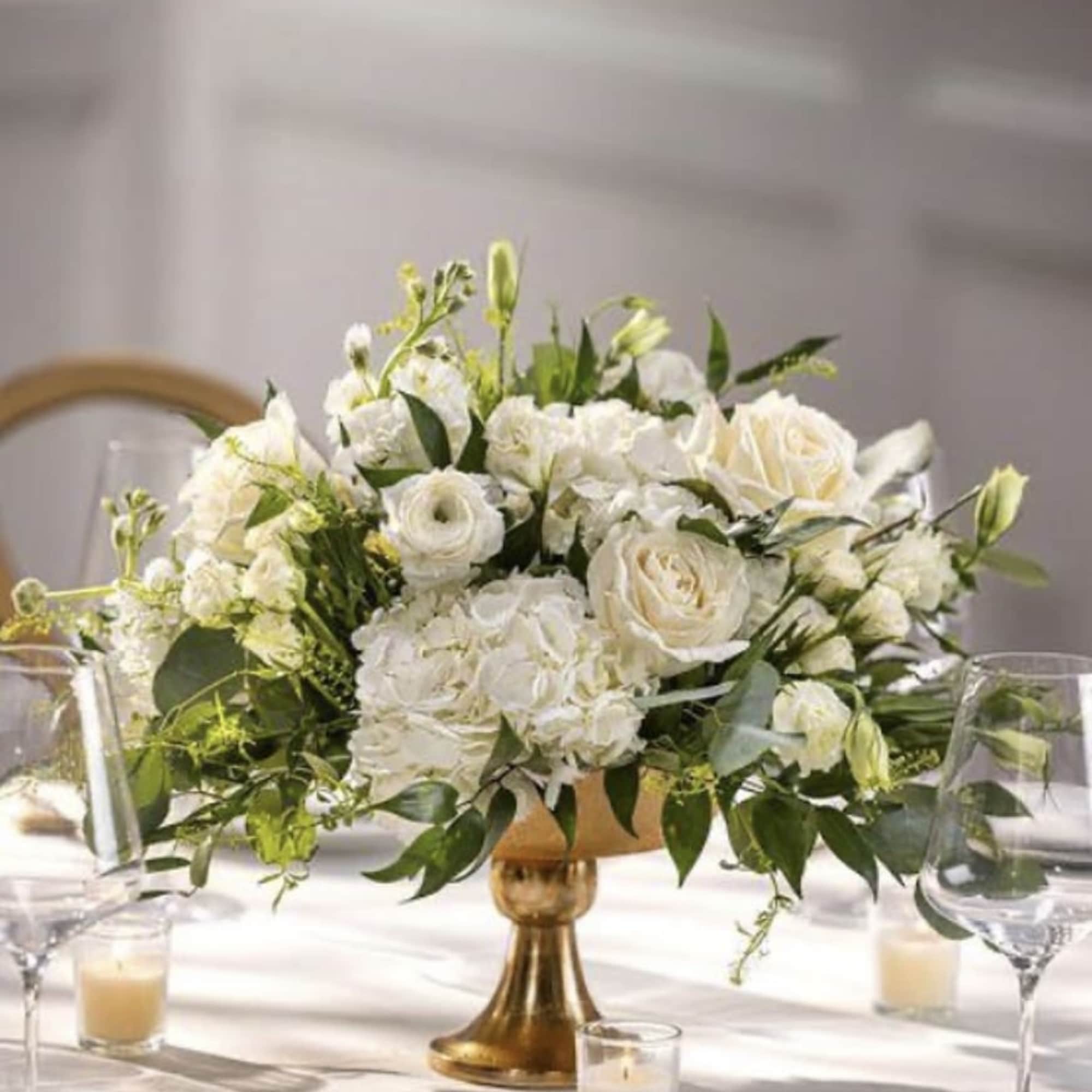 A timeless wedding centerpiece featuring white roses, hydrangeas, and lisianthus, elegantly arranged
