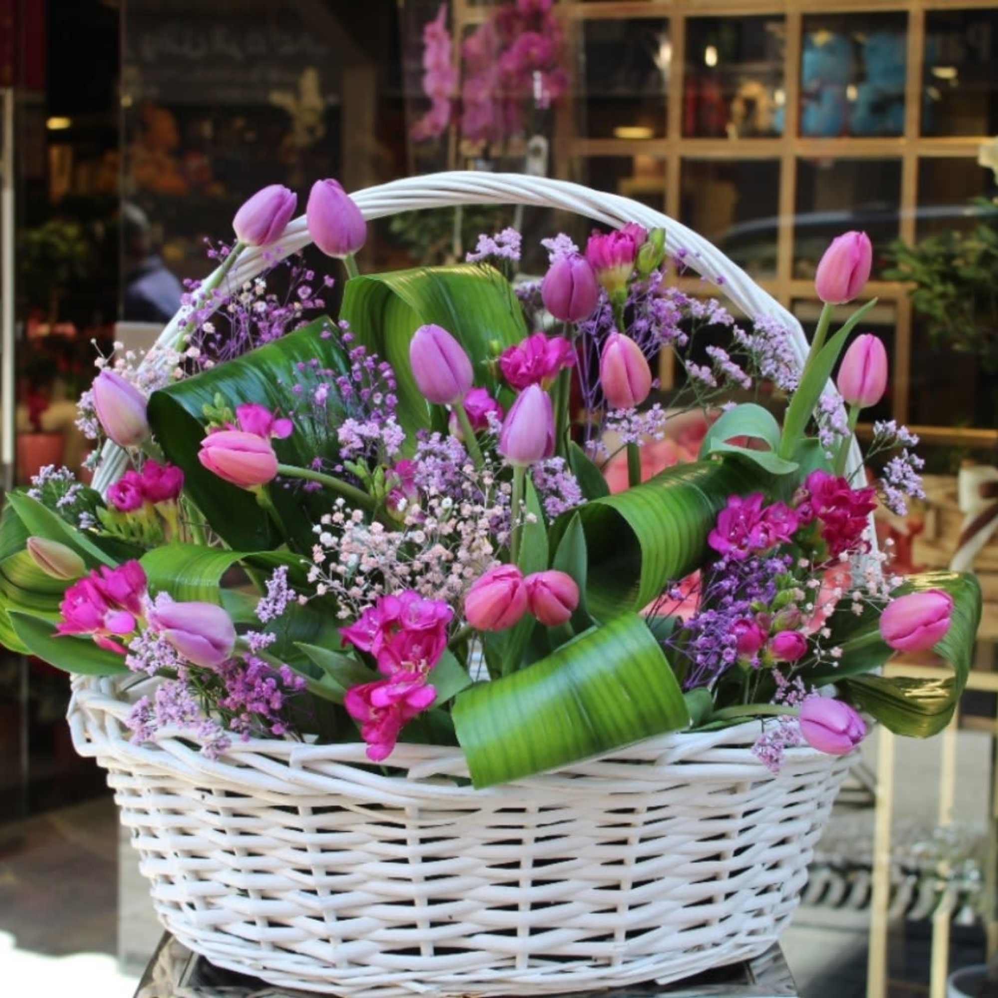 &ldquo;Blushing Elegance&rdquo; is a charming basket of pink tulips, and delicate baby&rsquo;s