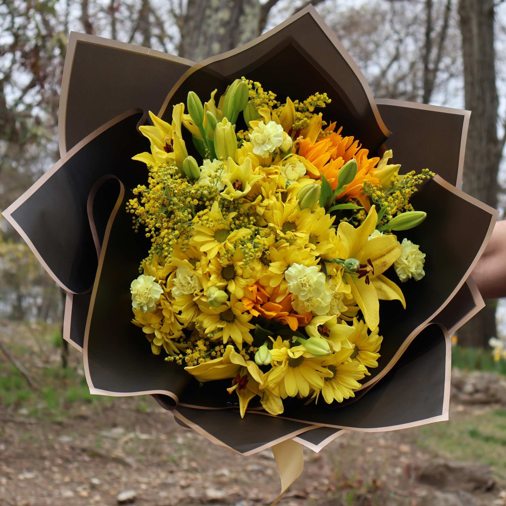A cheerful burst of sunshine, this bouquet features yellow lilies, golden daisies