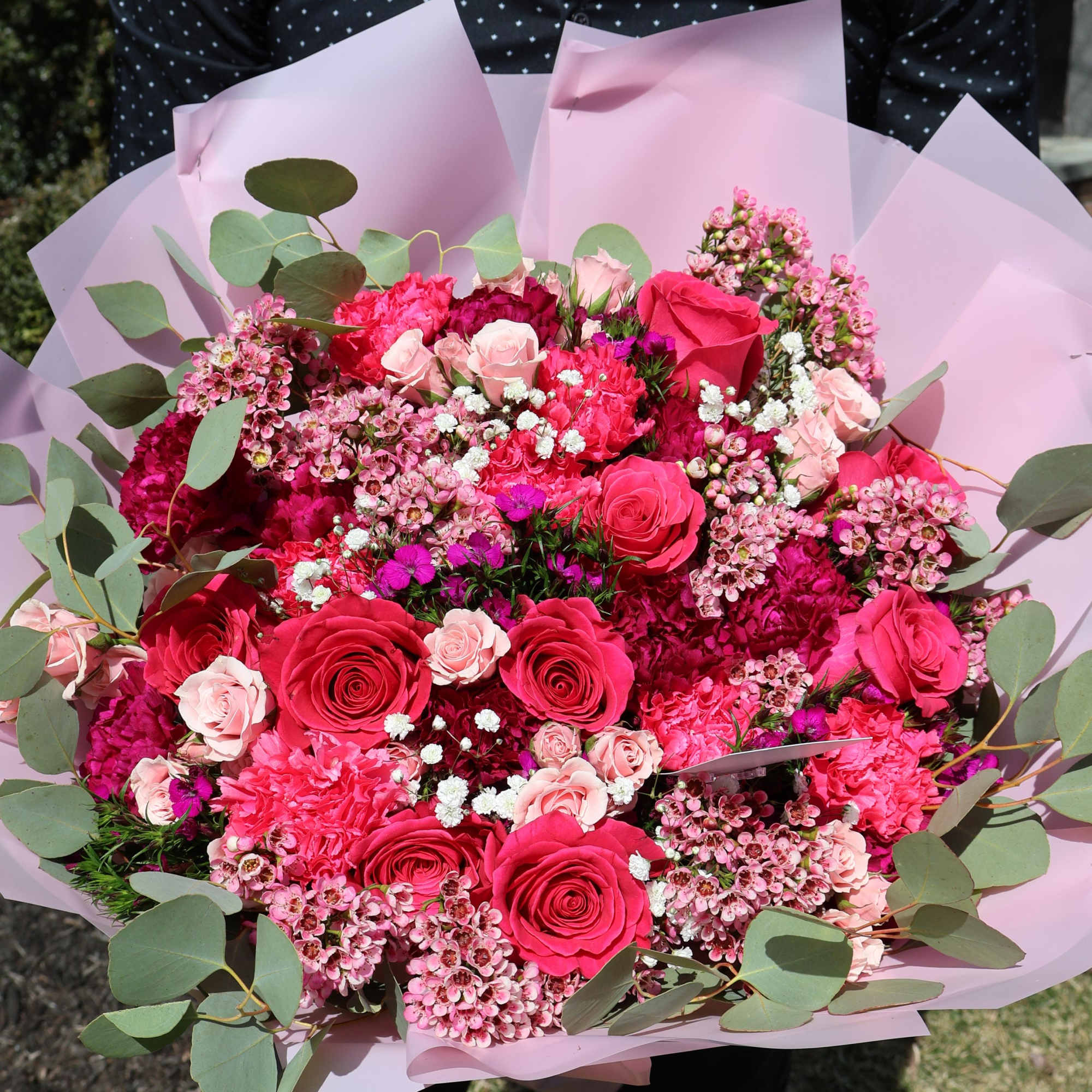 A romantic harmony of roses, carnations, and delicate filler flowers in shades