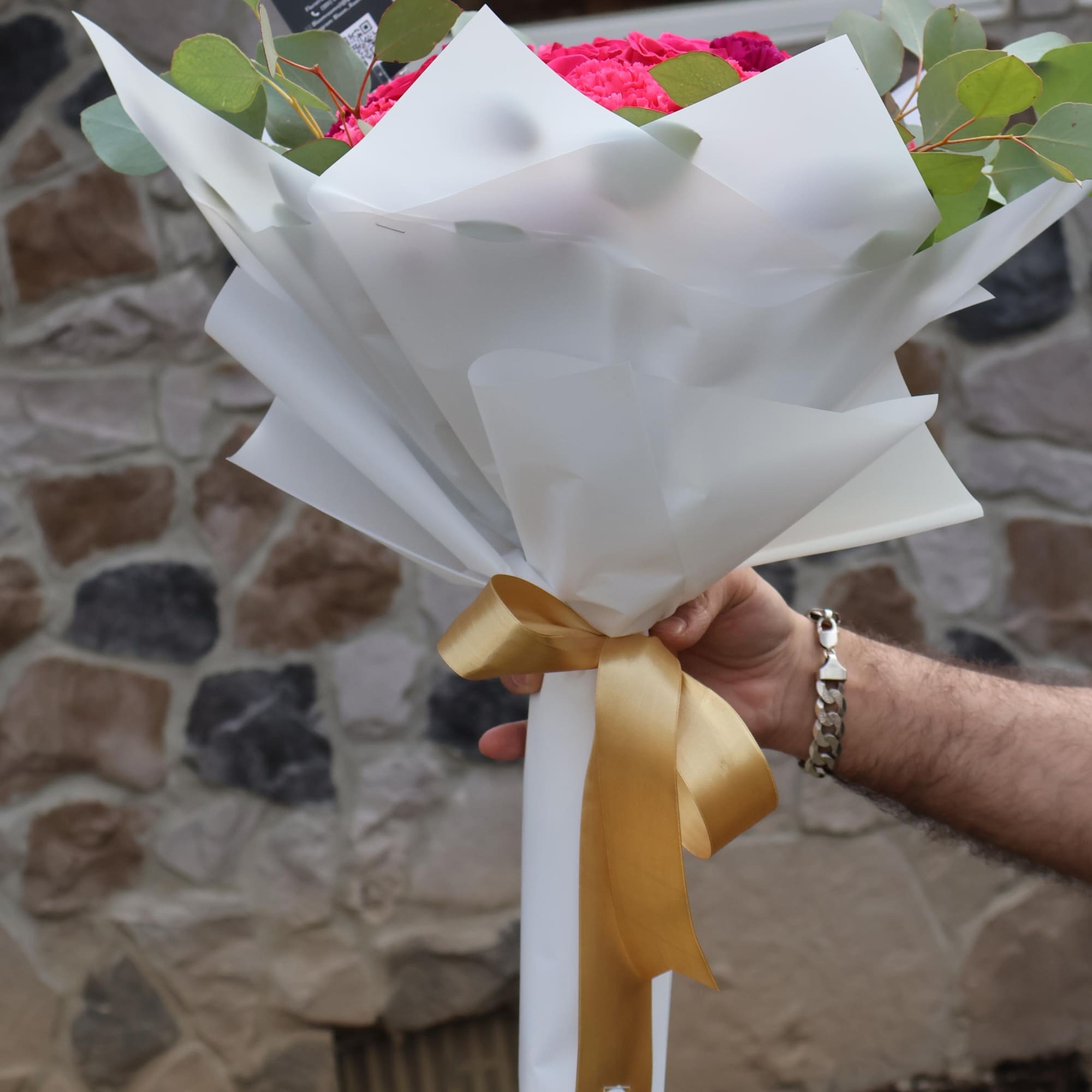 A striking fusion of hot pink roses and deep purple carnations, wrapped