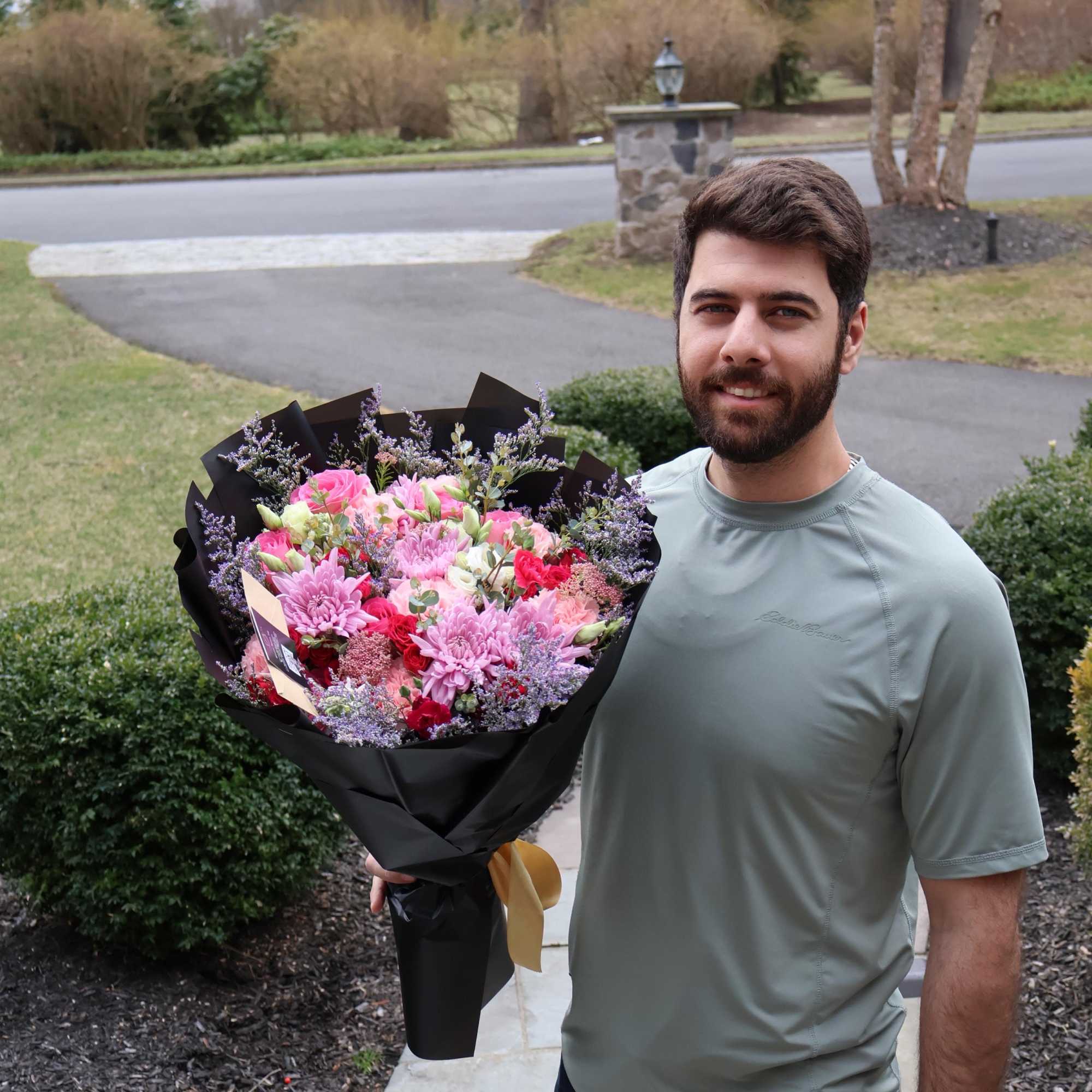 A lush mix of roses, carnations, and chrysanthemums in rich pinks and