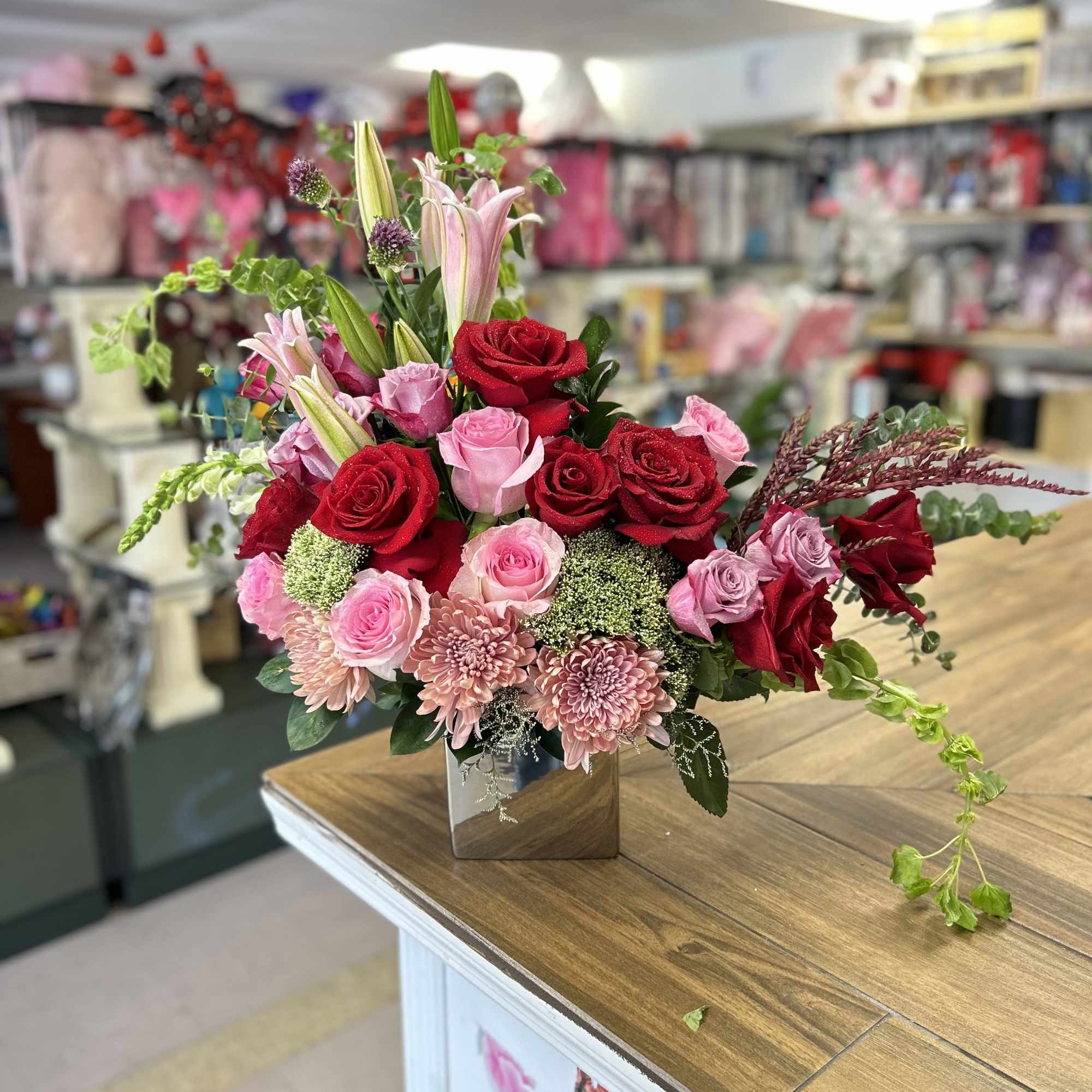 Exquisite floral arrangement in square base, with roses, lilies, chrysanthemums and fine