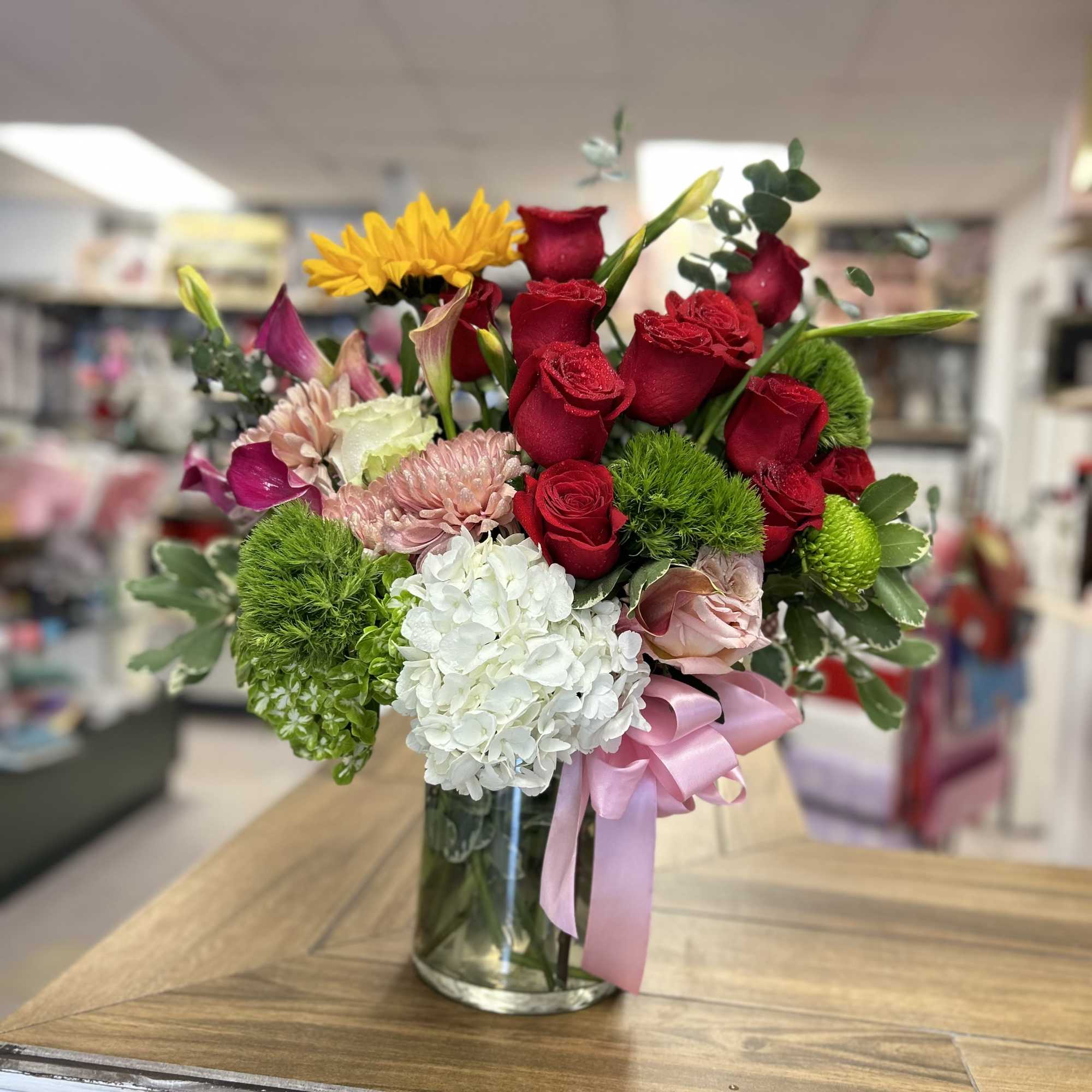 Beautiful and delicate floral arrangement in medium-sized glass cylinder, with roses mini