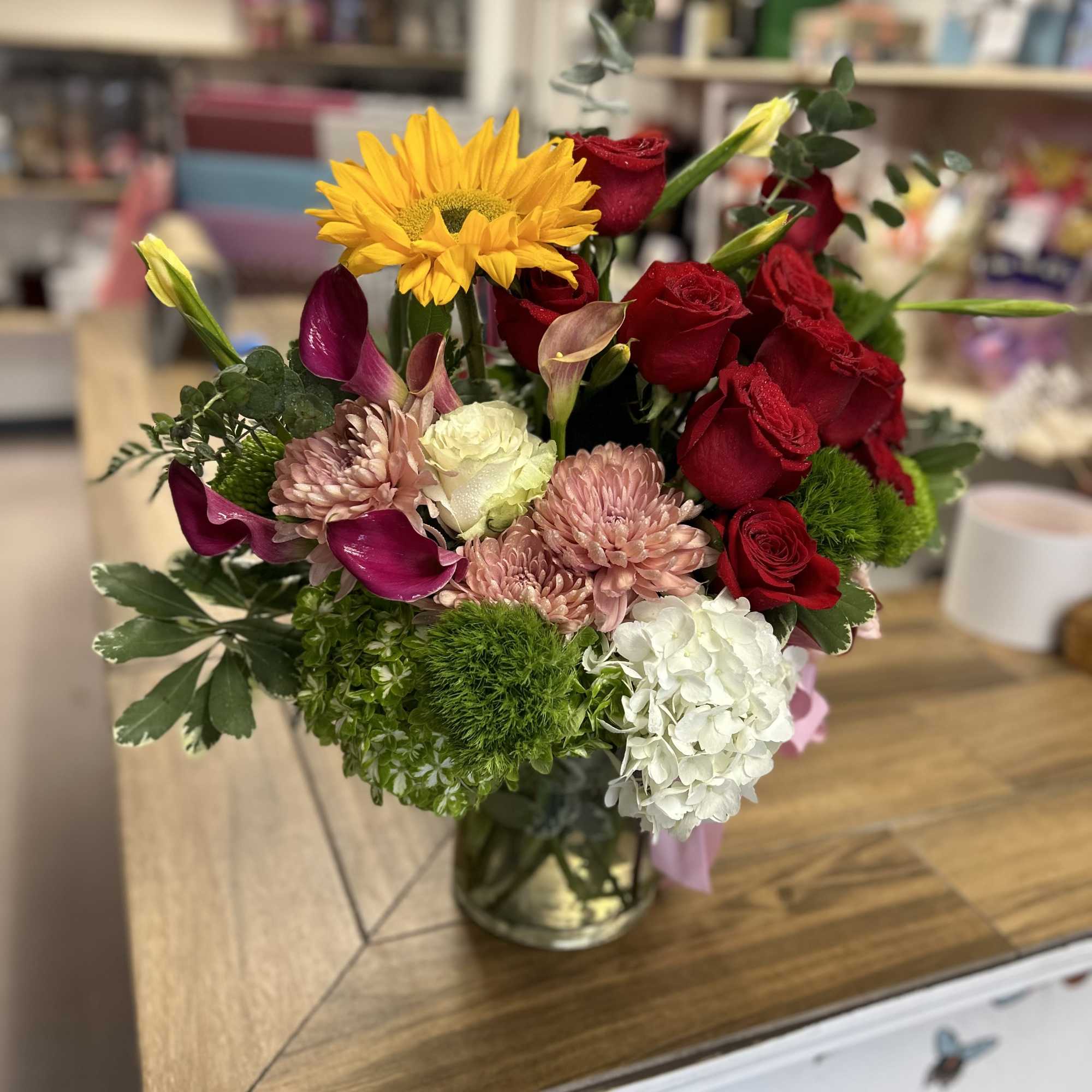 Beautiful and delicate floral arrangement in medium-sized glass cylinder, with roses mini