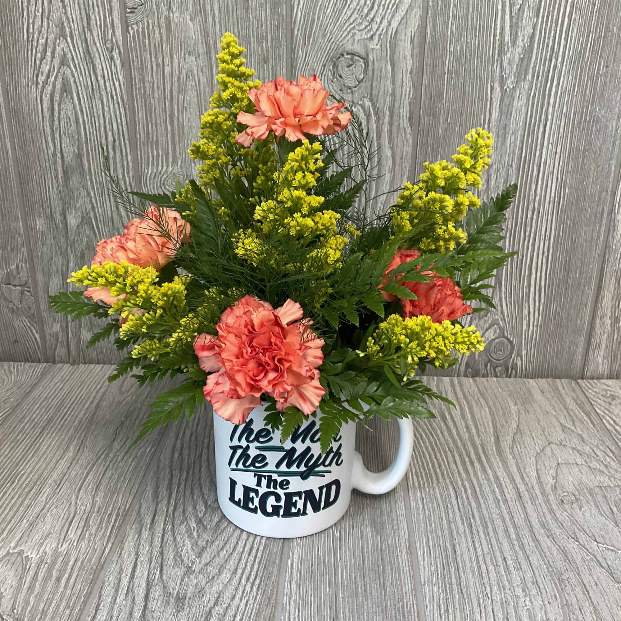 Fresh cut flowers in a keepsake ceramic mug. Flowers and colors may Fresh cut flowers in a keepsake ceramic mug. Flowers and colors may