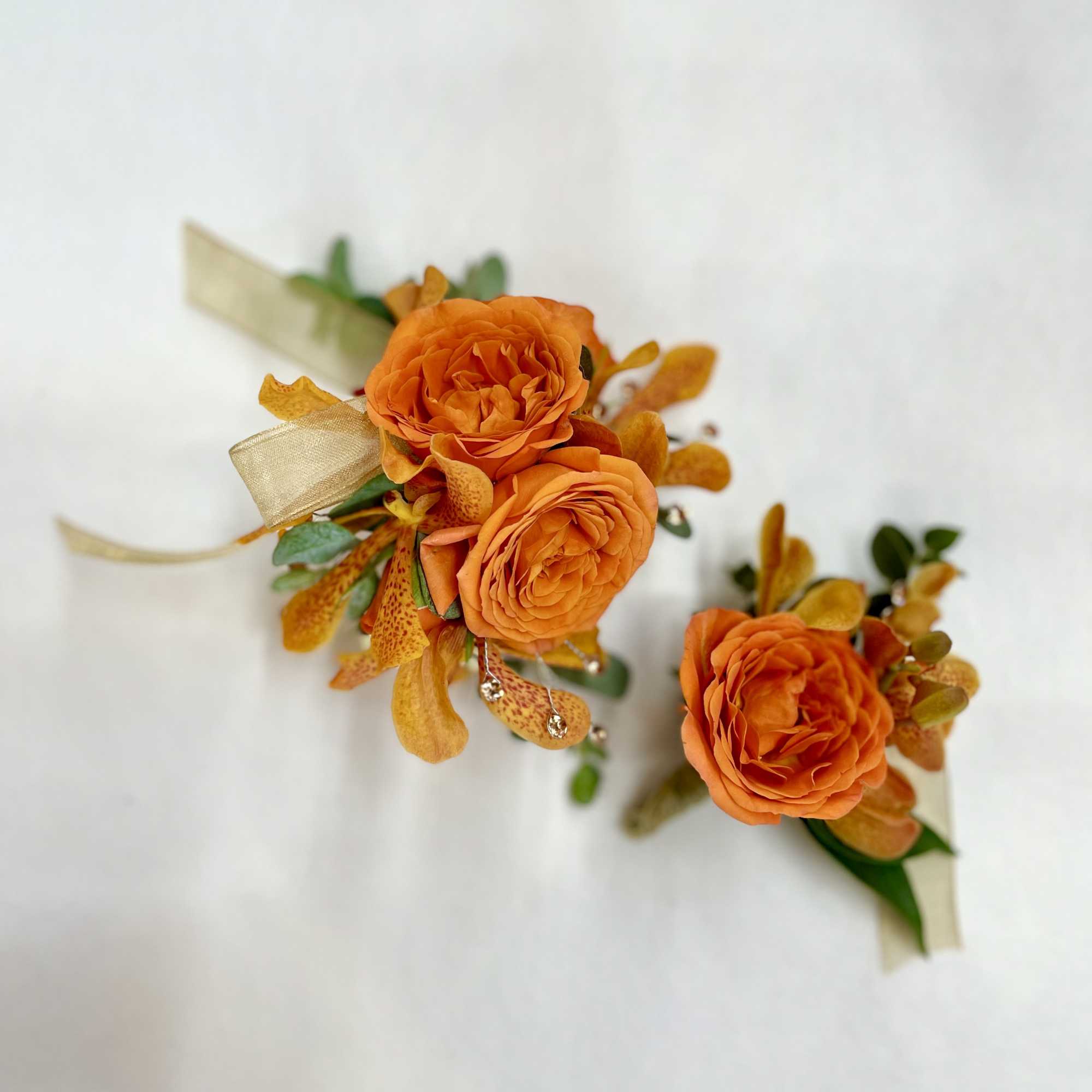 Classic orange wrist corsage and boutonni&egrave;re with orchid and other blooms. The