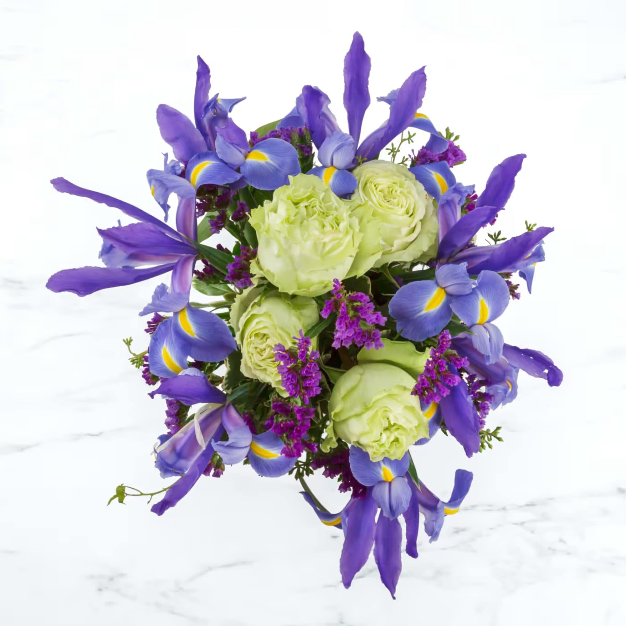 A white box vase, green roses, and vivid blue iris make this