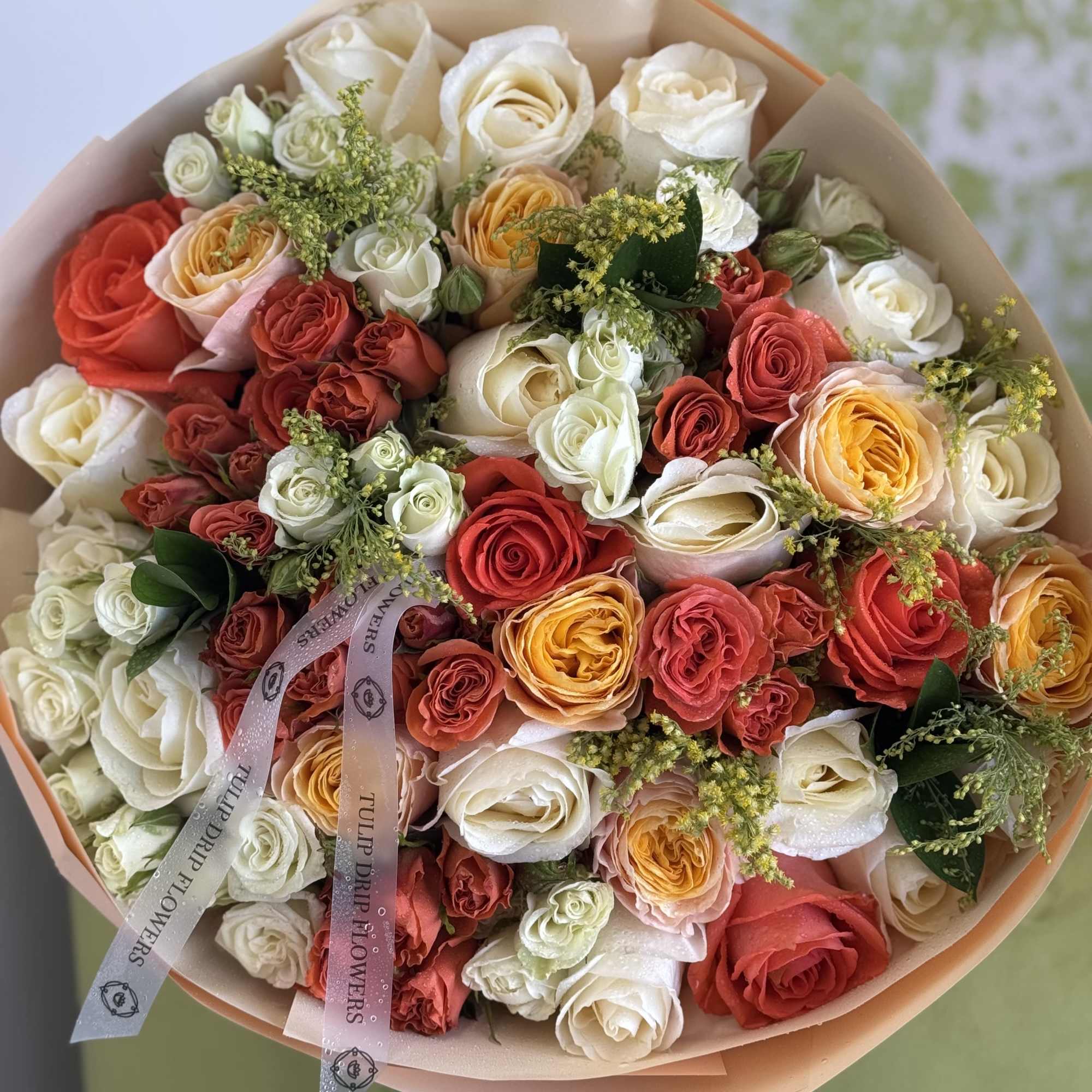 An abundant bouquet of cream, peach, and burnt orange garden roses wrapped