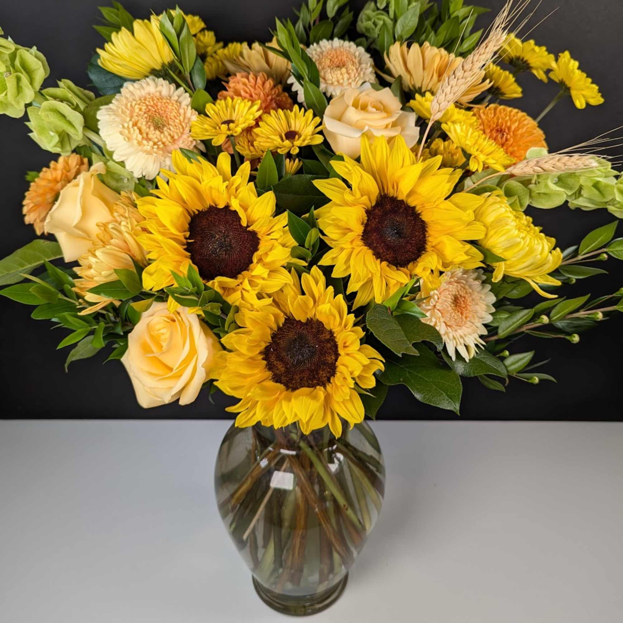 Embrace the cheerful radiance of our Sunny Sunflower Delight. This vibrant arrangement Embrace the cheerful radiance of our Sunny Sunflower Delight. This vibrant arrangement