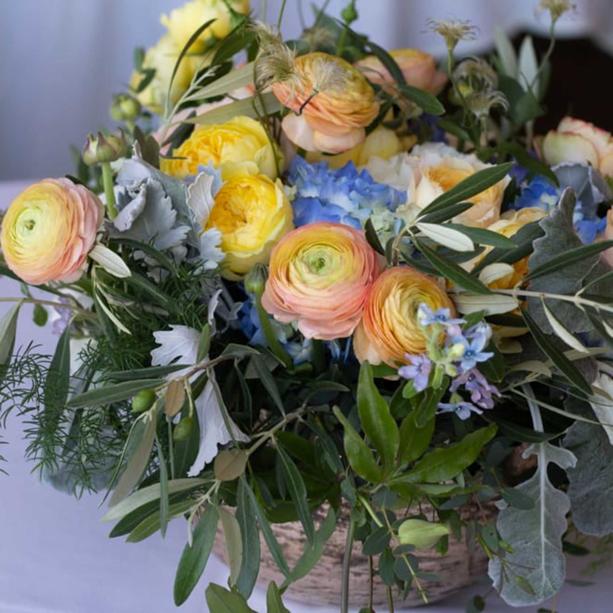 A lush green centerpiece with bright accents from seasonal flowers.  A lush green centerpiece with bright accents from seasonal flowers.