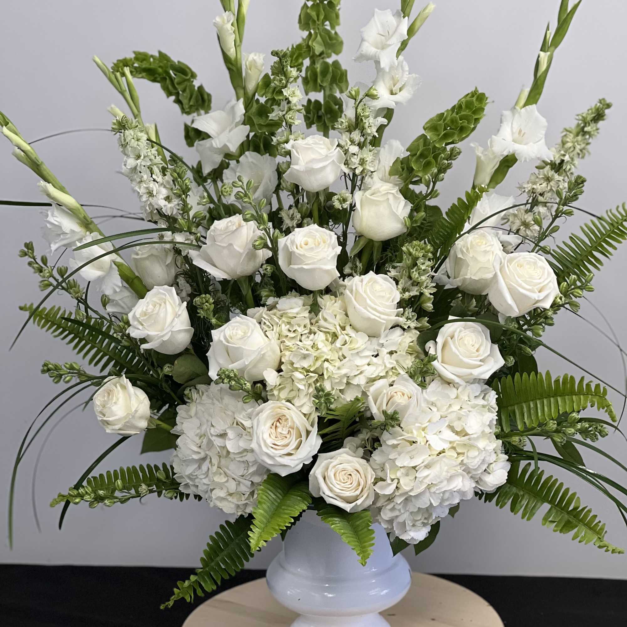 An all white tribute, this funeral basket is pure and tranquil. Featuring