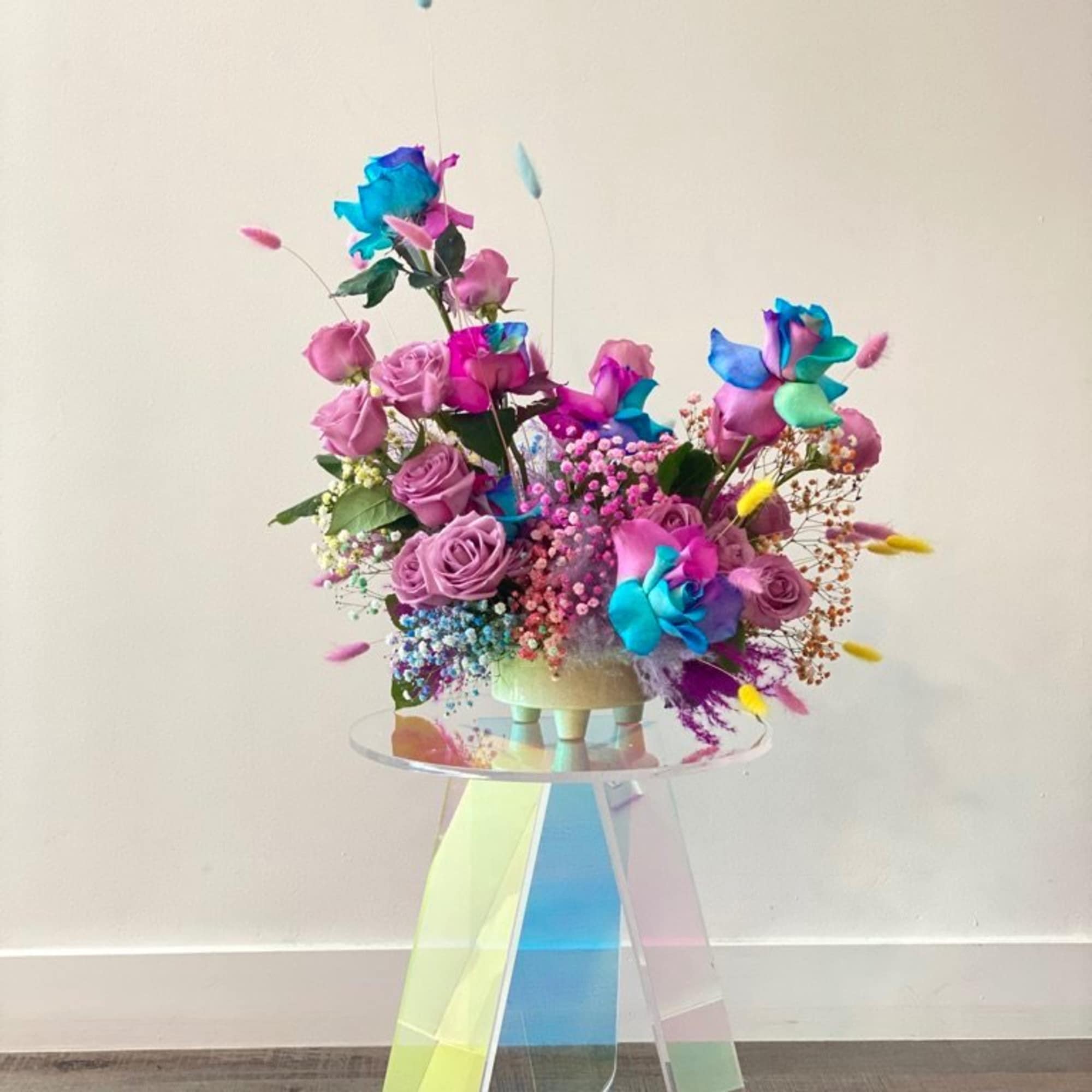 - Delights the senses with vibrant multicolored roses
- Includes whimsical bunnytail and