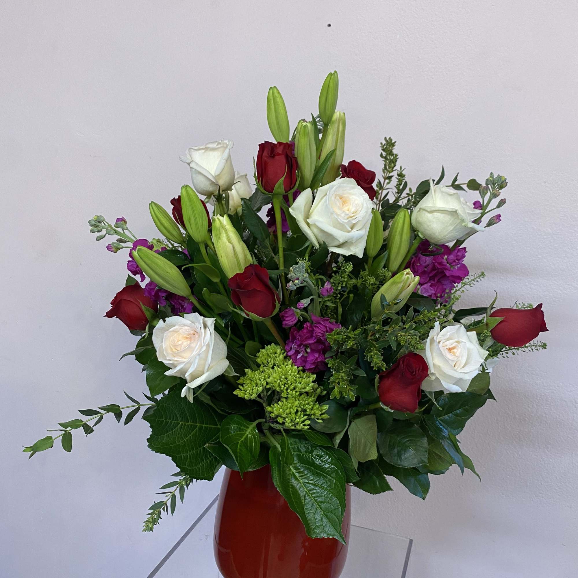 This captivating arrangement harmoniously blends the timeless beauty of white garden roses
