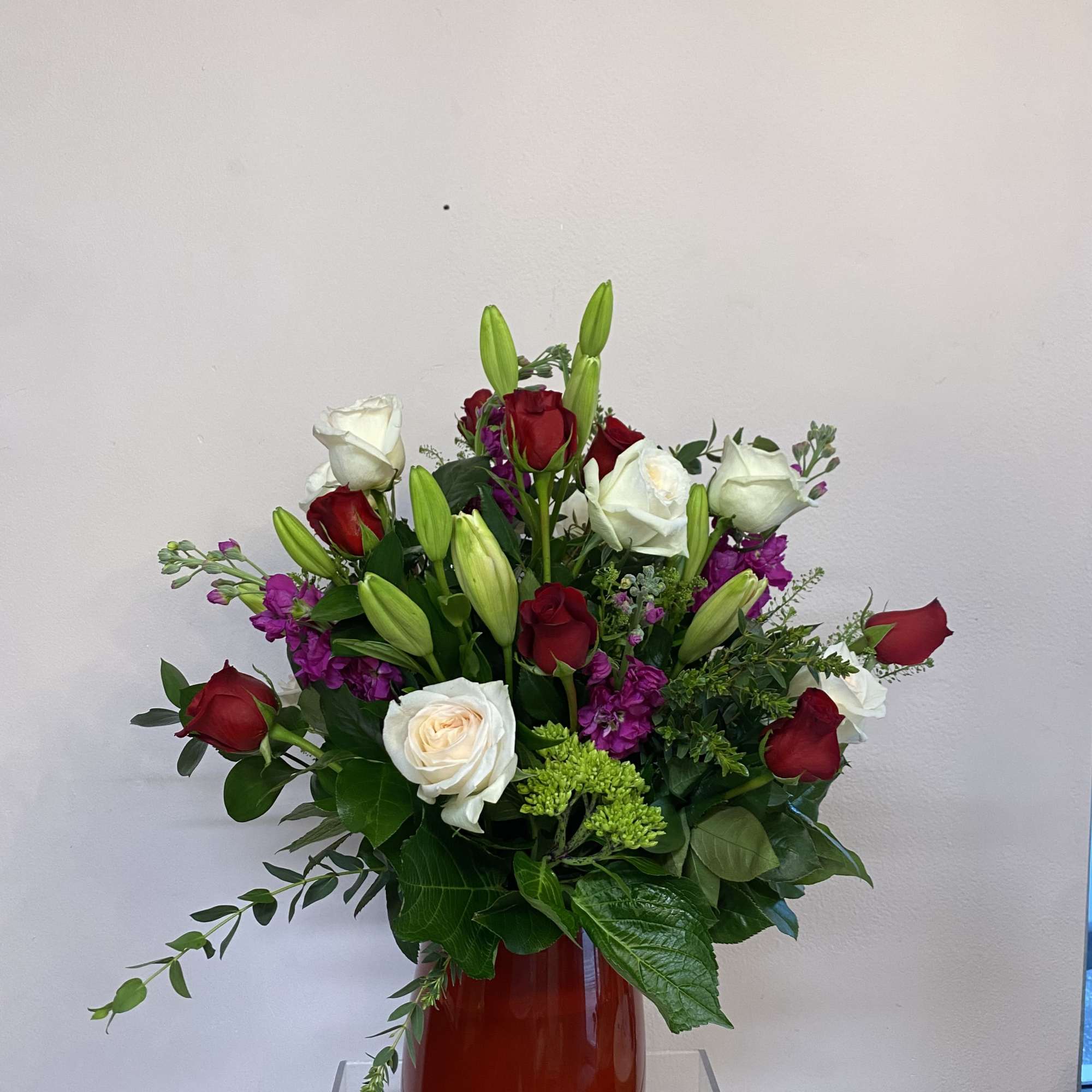 This captivating arrangement harmoniously blends the timeless beauty of white garden roses
