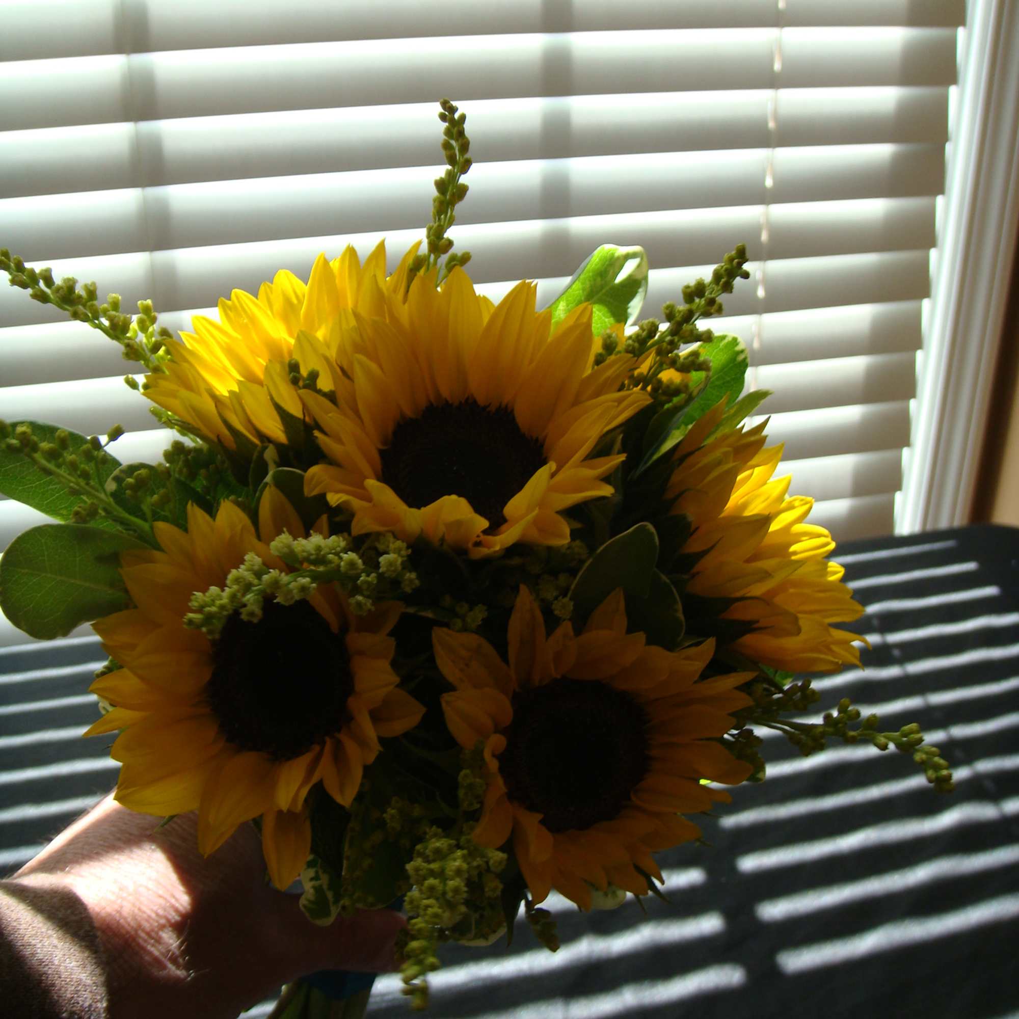 Hand Tied Bouquet with mini sunflowers, greenery, filler and ribbon.