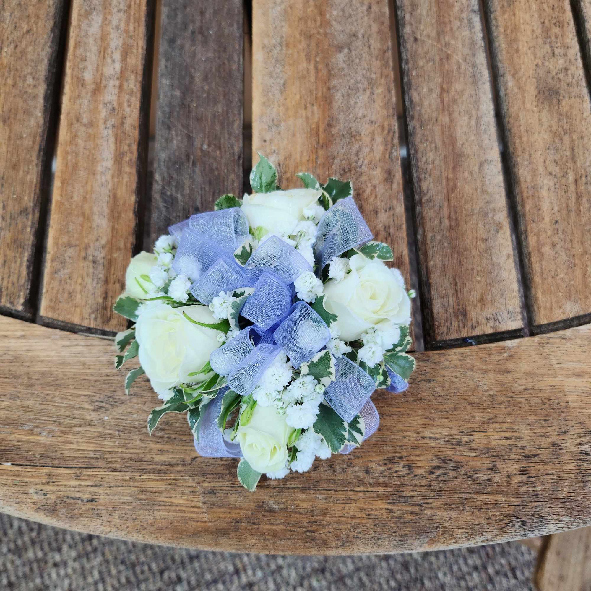Wrist corsage with white spray roses, filler, greenery and ribbon 