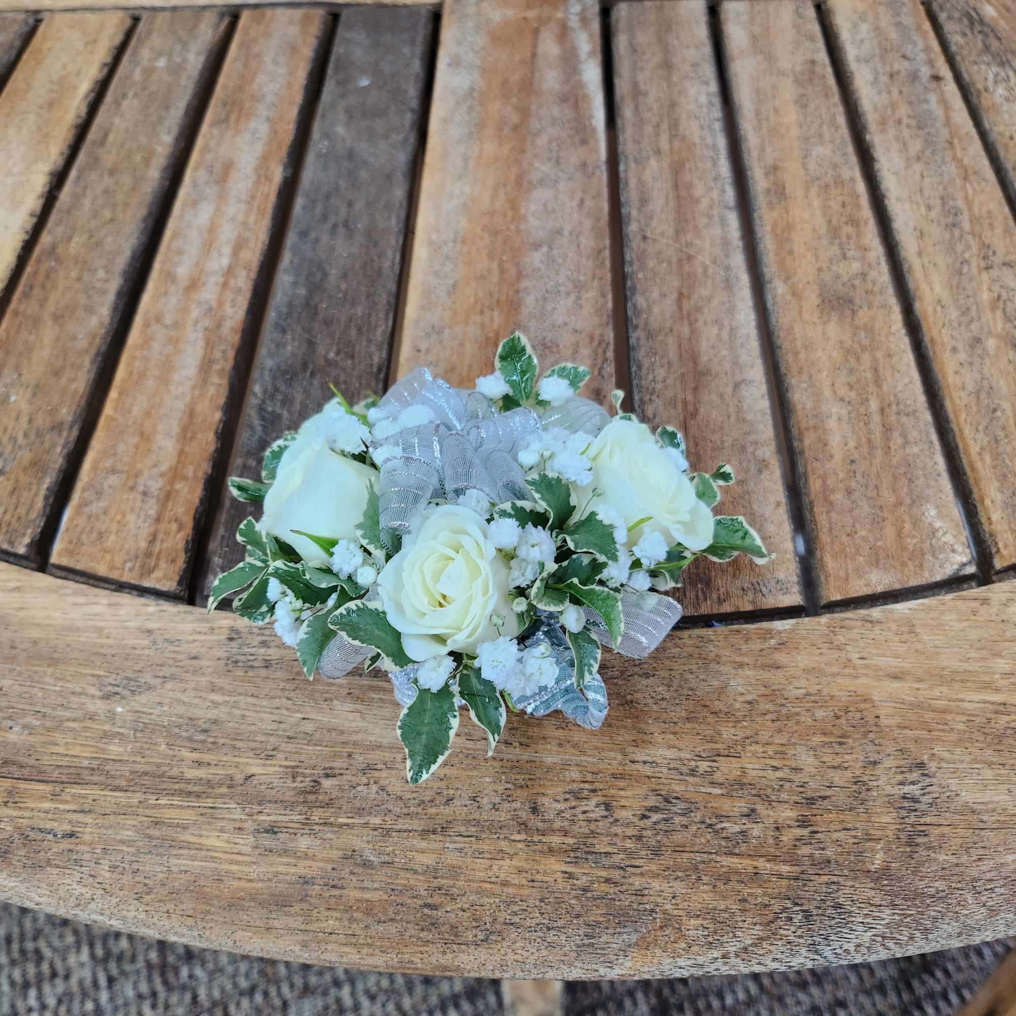 Wrist Corsage with white spray roses, greenery, filler, and silver Ribbon