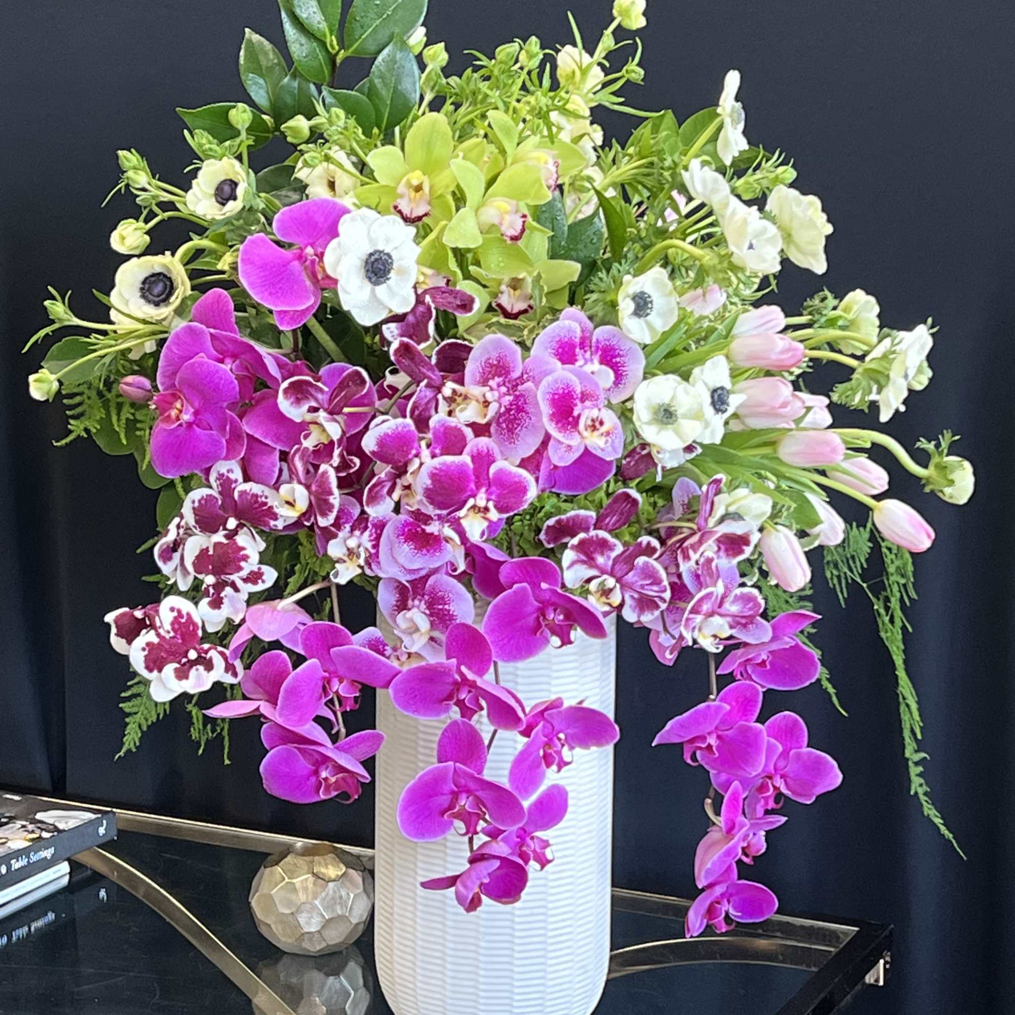 pink and white Phalaenopsis orchids and cream hydrangeas with decorative monstera leaves