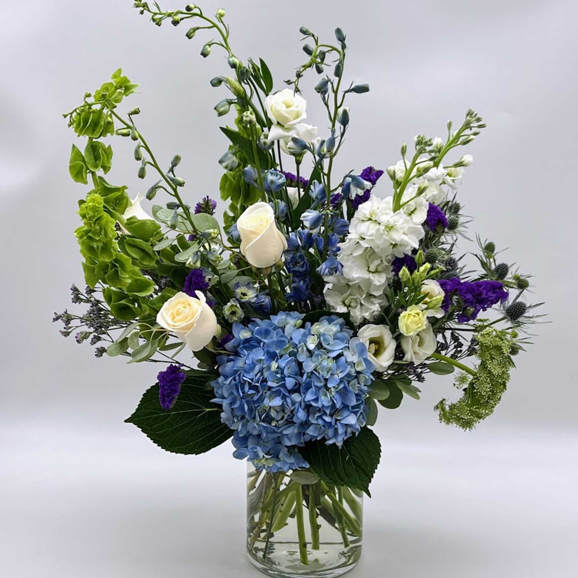 In this designer beautiful arrangement, the serenity of the blue hydrangeas and In this designer beautiful arrangement, the serenity of the blue hydrangeas and