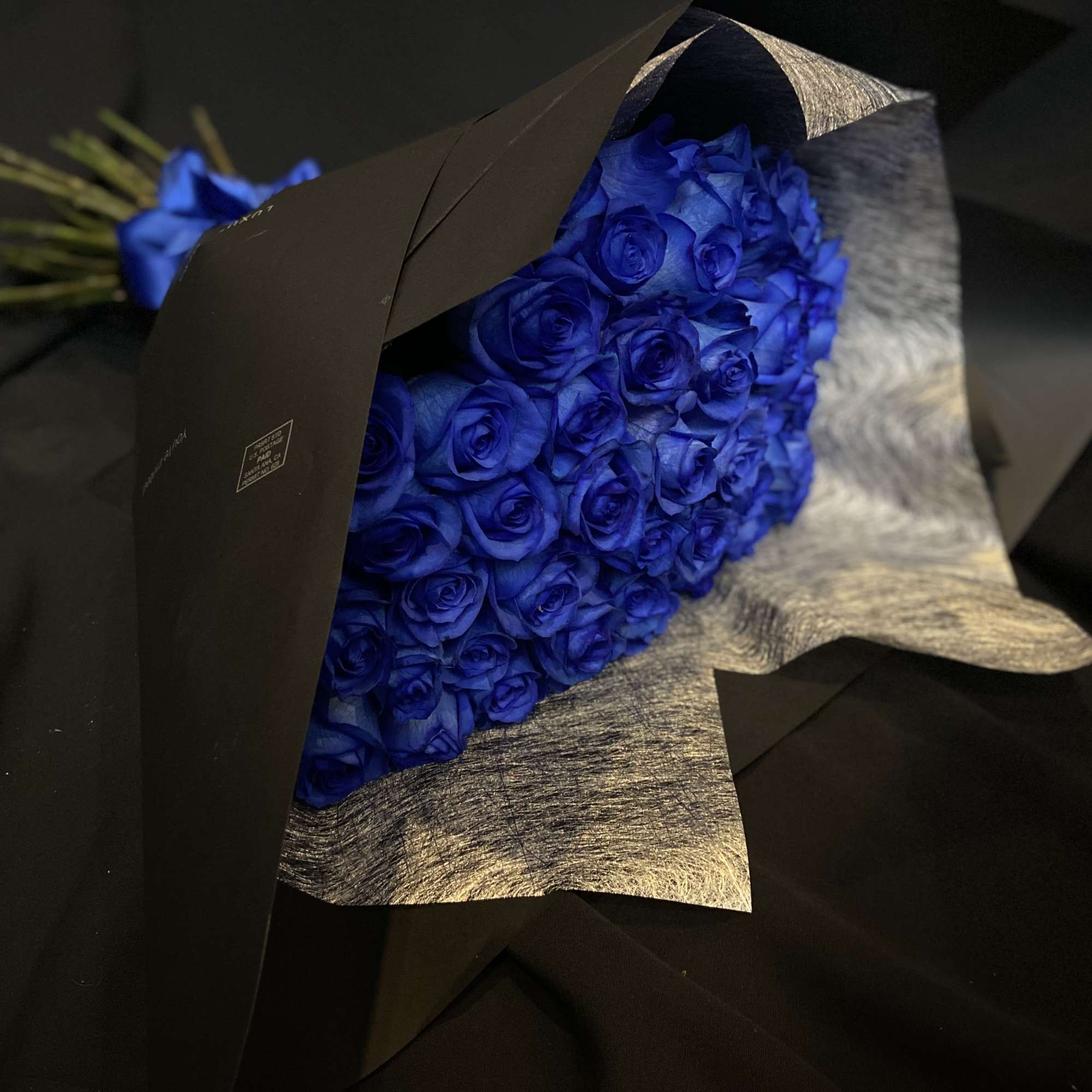 2 Dozen Blue Roses Wrapped with Black Paper and Blue Ribbon.