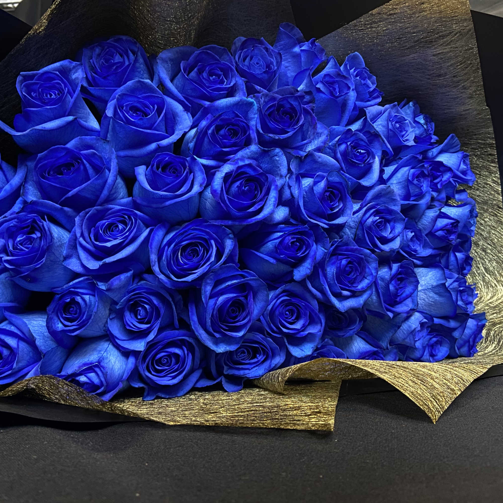 2 Dozen Blue Roses Wrapped with Black Paper and Blue Ribbon.