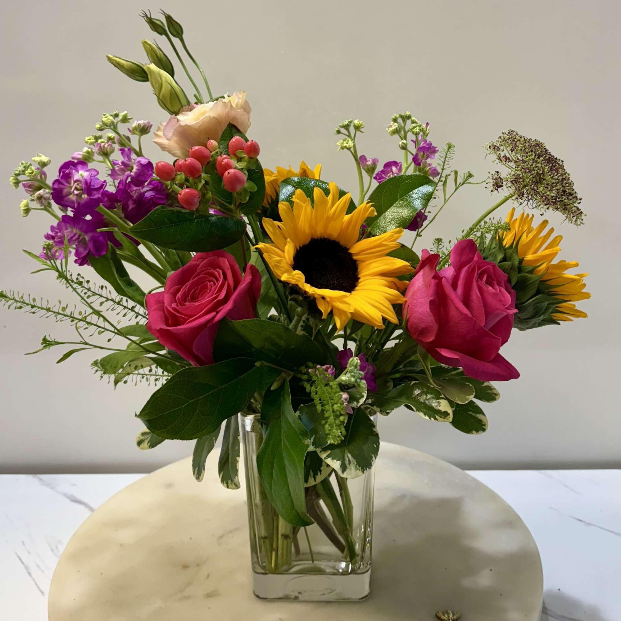 A striking modern arrangement featuring bold sunflowers, sleek greenery, and contemporary accents A striking modern arrangement featuring bold sunflowers, sleek greenery, and contemporary accents