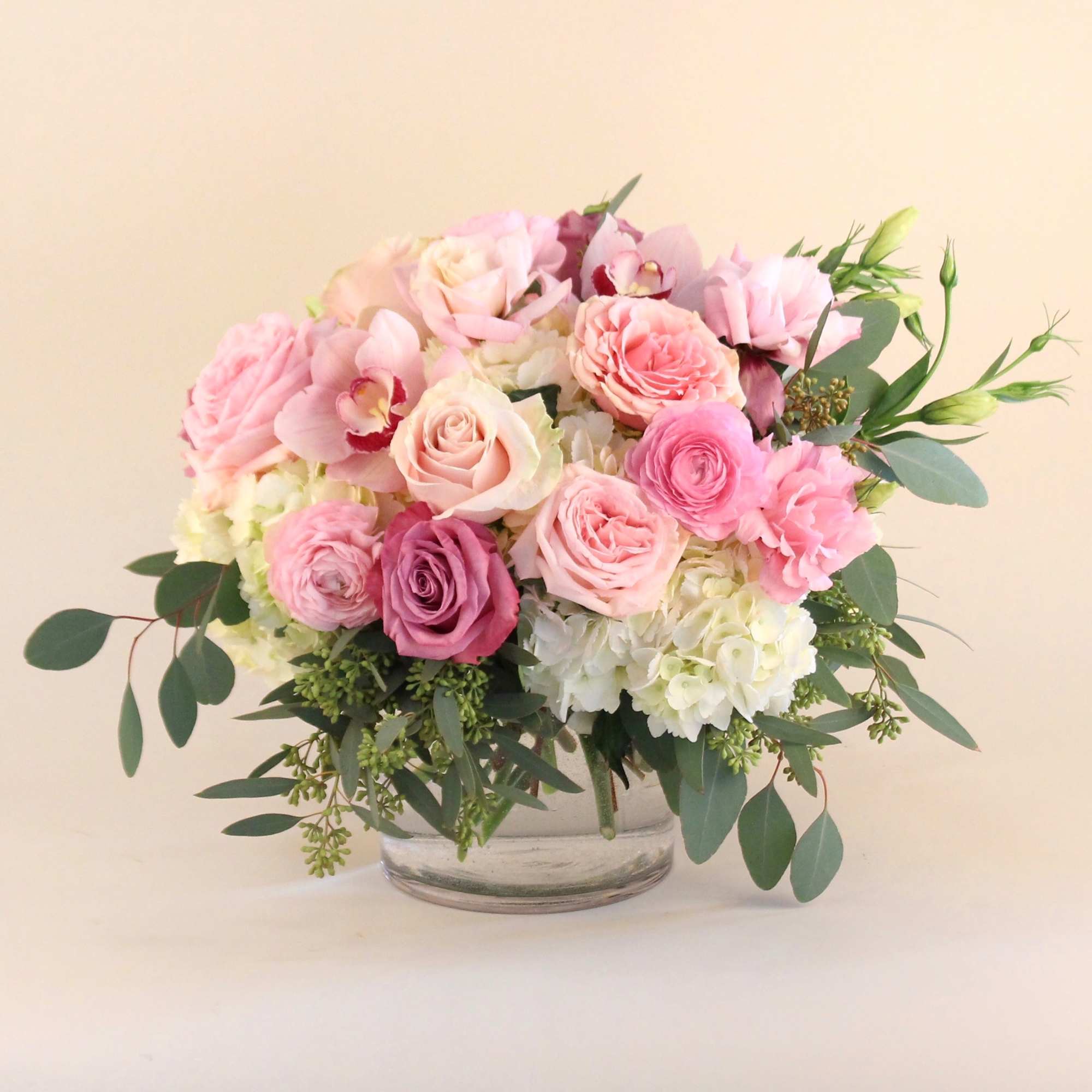 A romantic arrangement of blush, white and lavender flowers in a clear