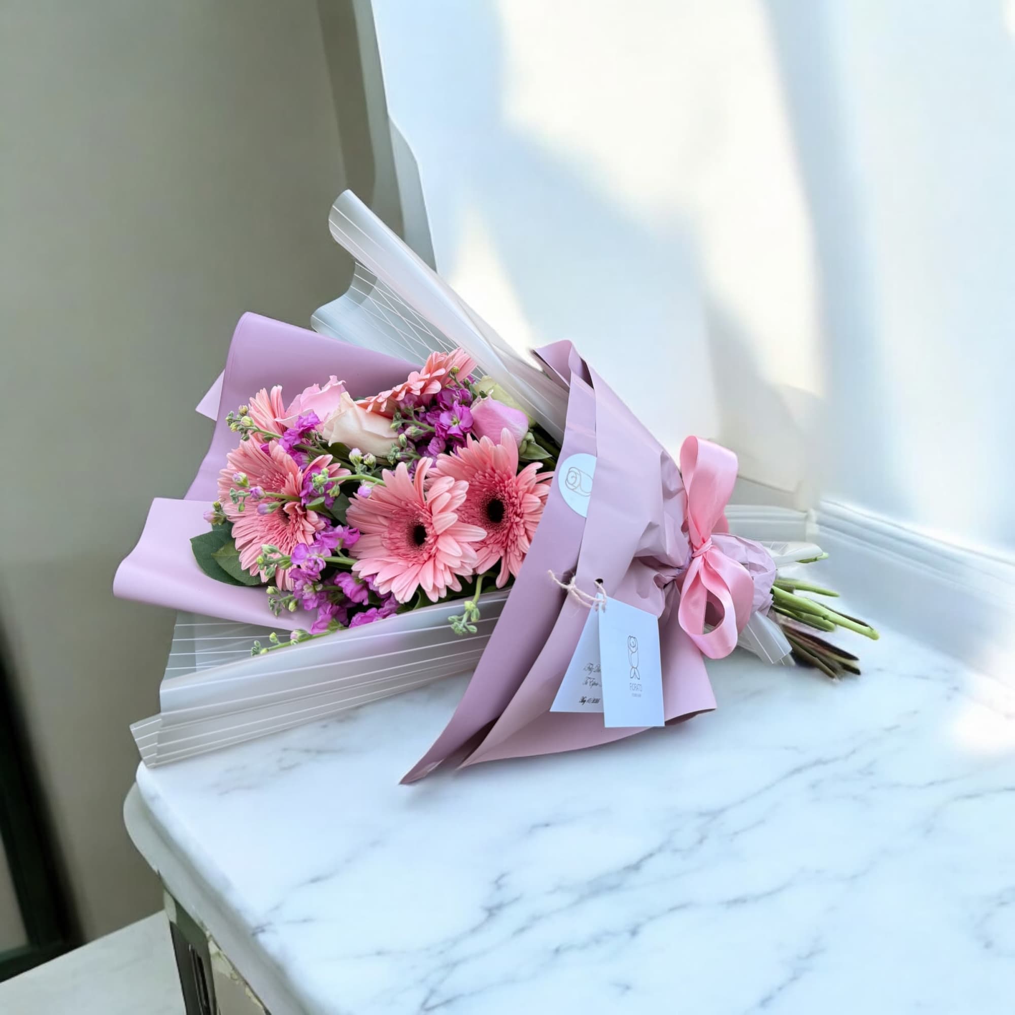 A soft and graceful bouquet blending delicate blooms in muted tones, wrapped