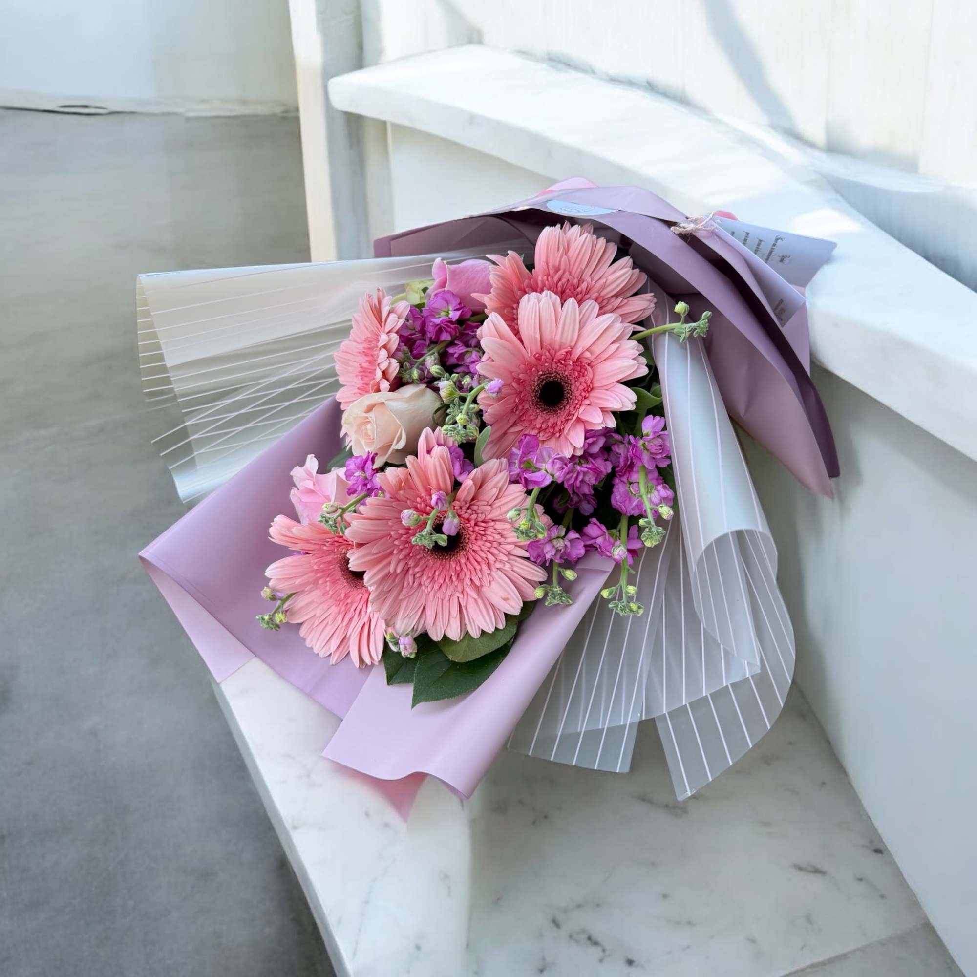 A soft and graceful bouquet blending delicate blooms in muted tones, wrapped