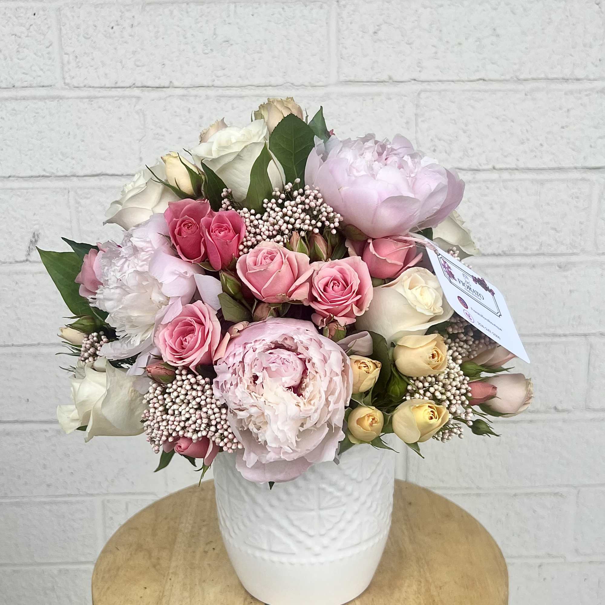 A round bouquet blending delicate peonies and roses with the soft texture