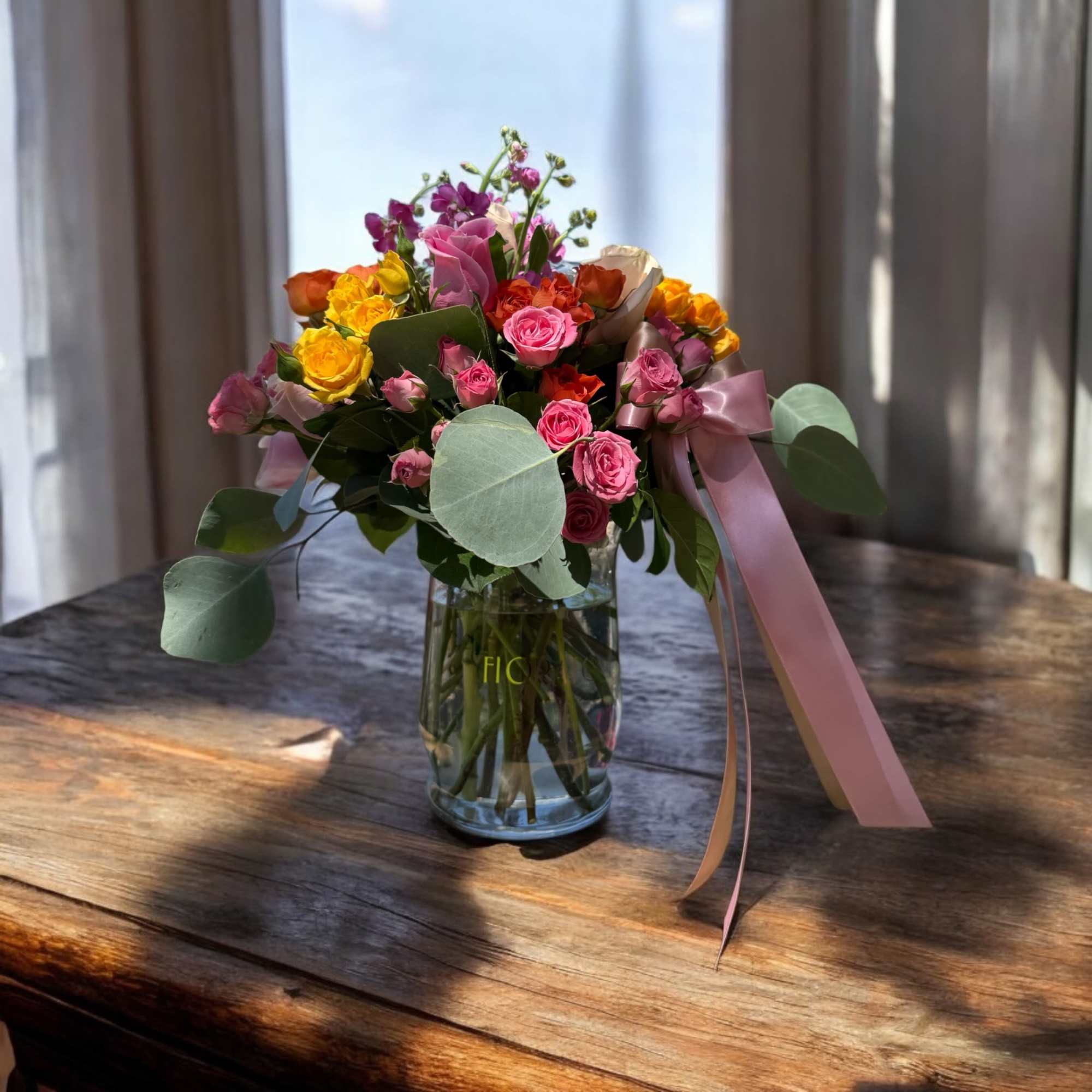 A bouquet that celebrates life in every bloom. Roses in fuchsia, coral