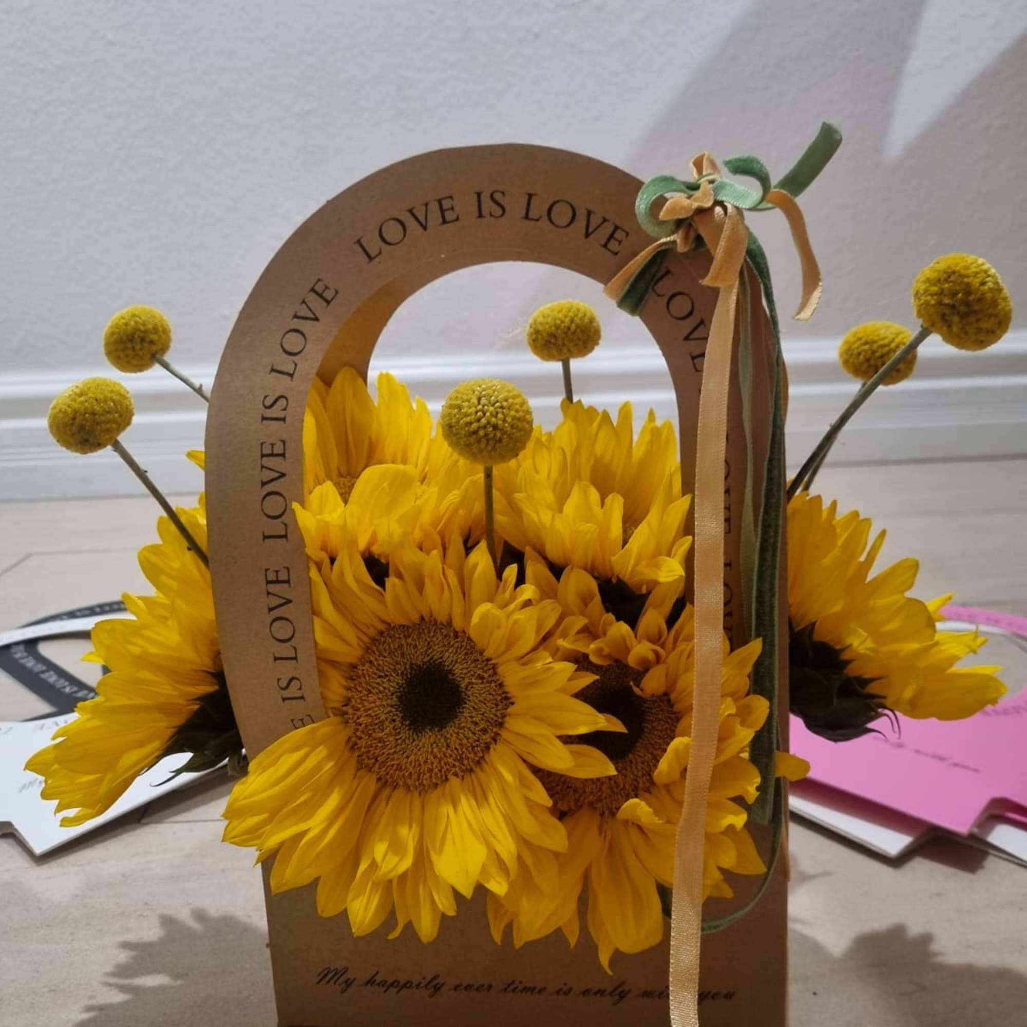 Nestled in charming kraft tote that reads love is love, this floral