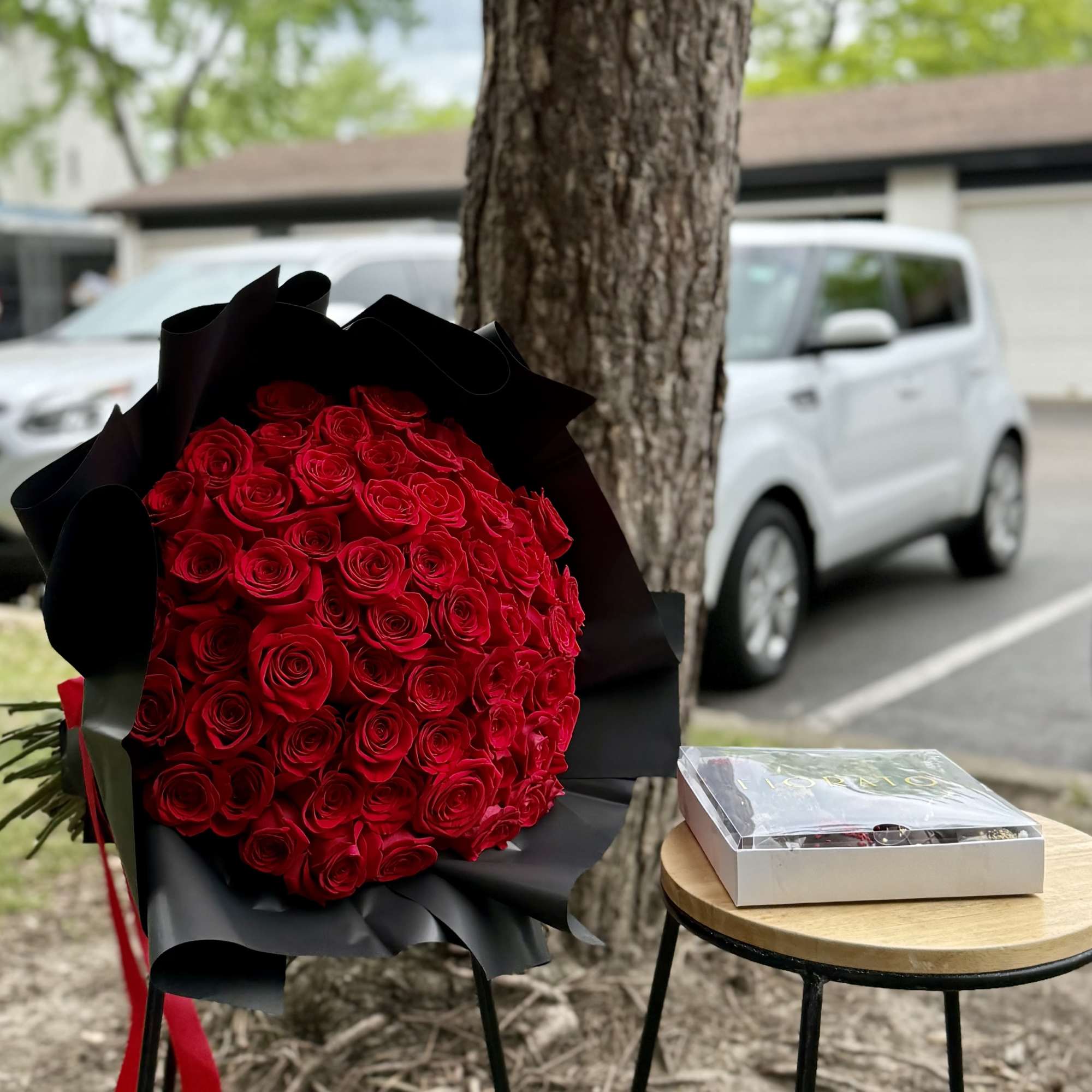 A luxurious bouquet of over 50 red roses, carefully wrapped in sleek