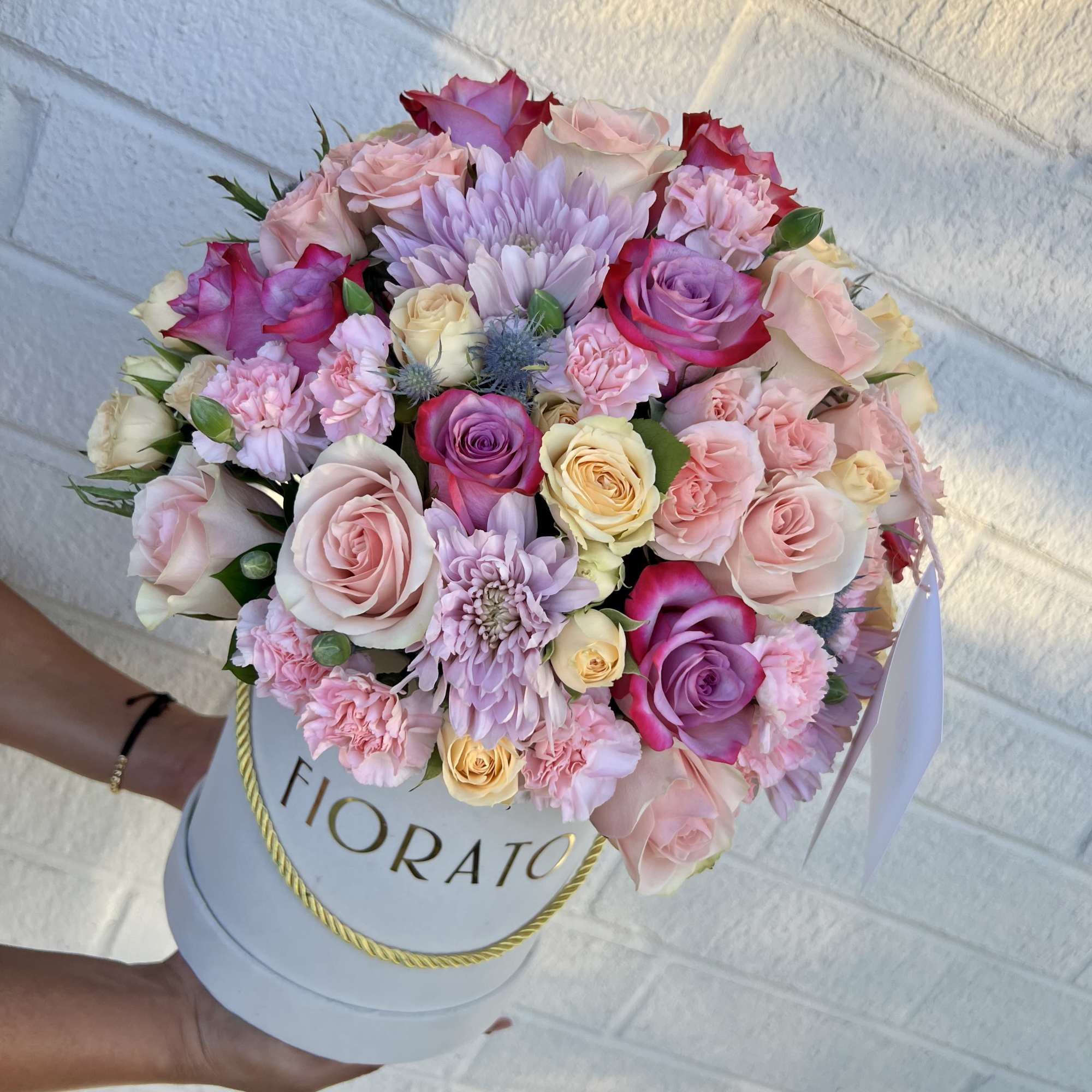 An ethereal and elegant design in a round box, featuring roses in