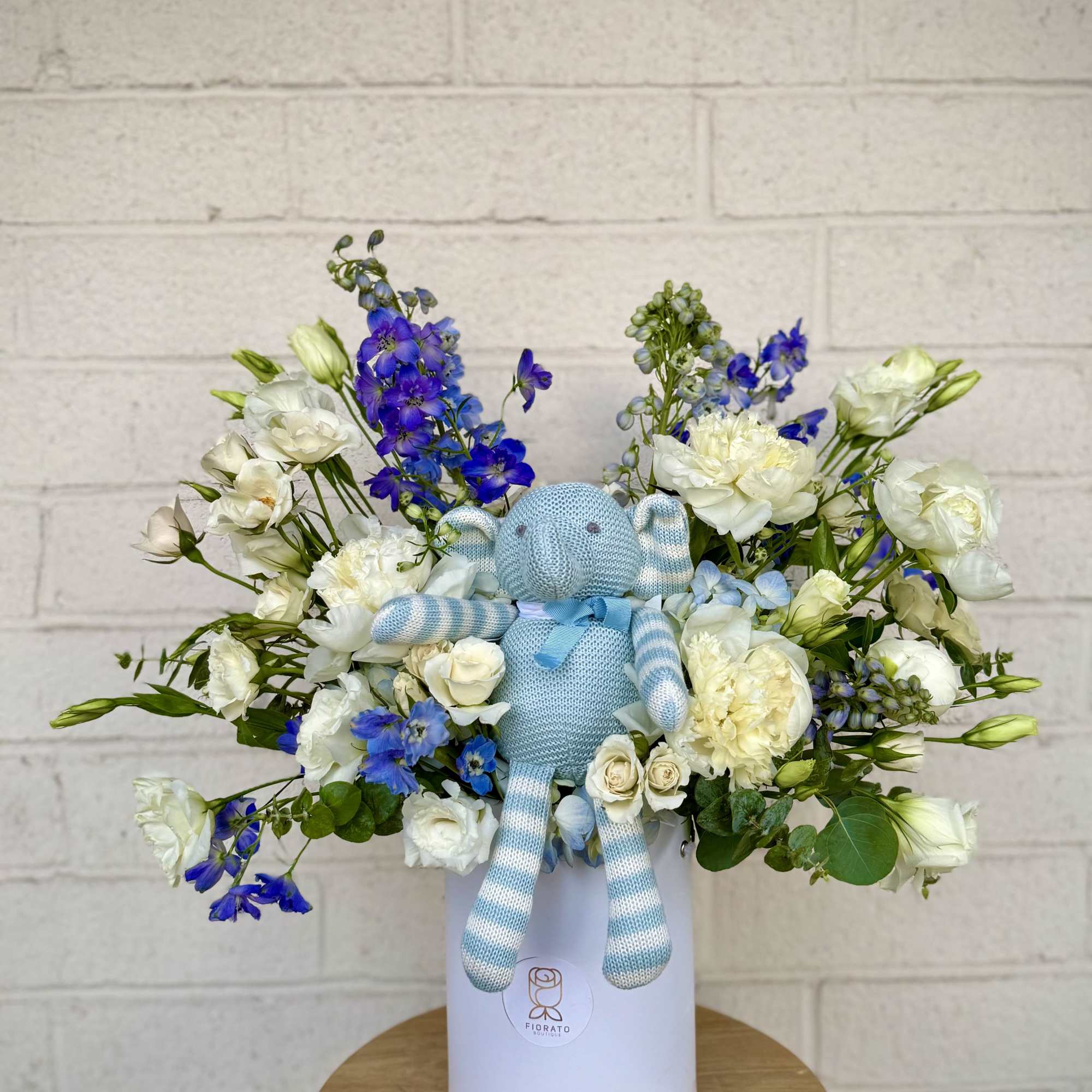 A charming mix of white and soft blue-toned flowers, beautifully arranged with