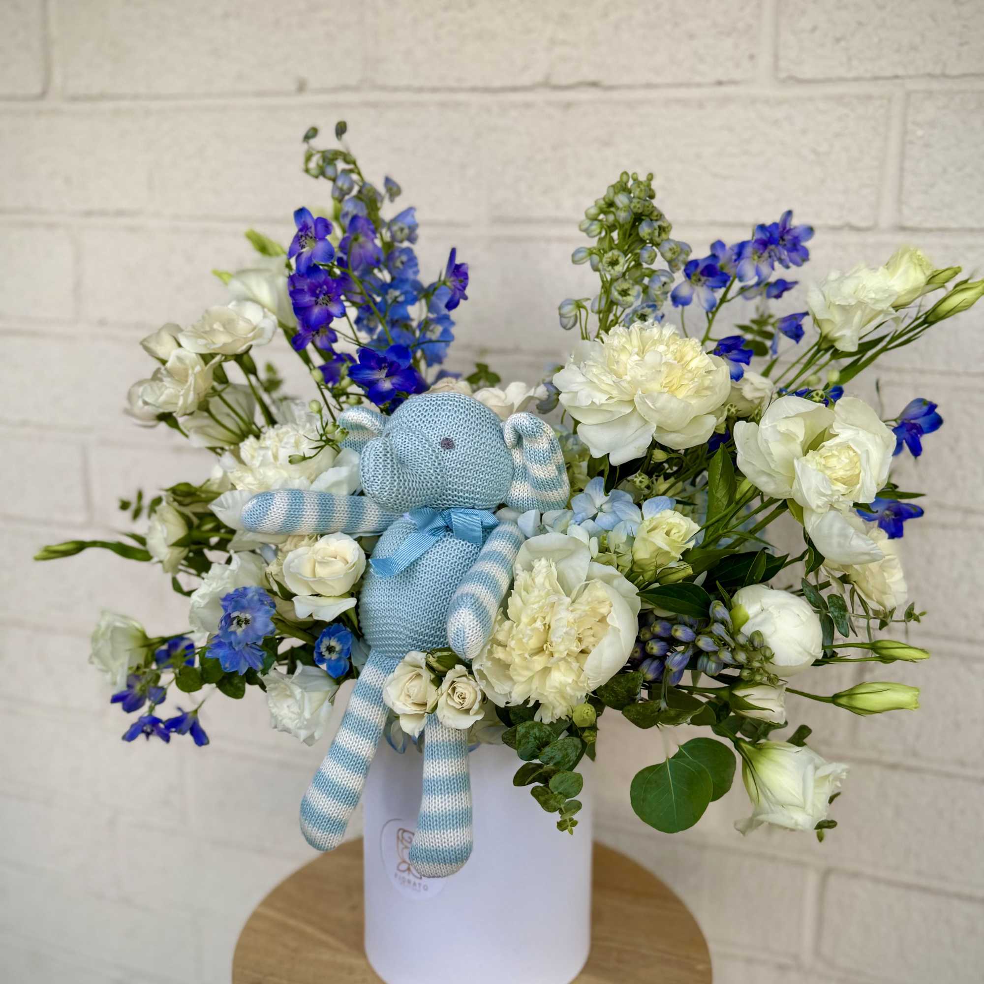A charming mix of white and soft blue-toned flowers, beautifully arranged with
