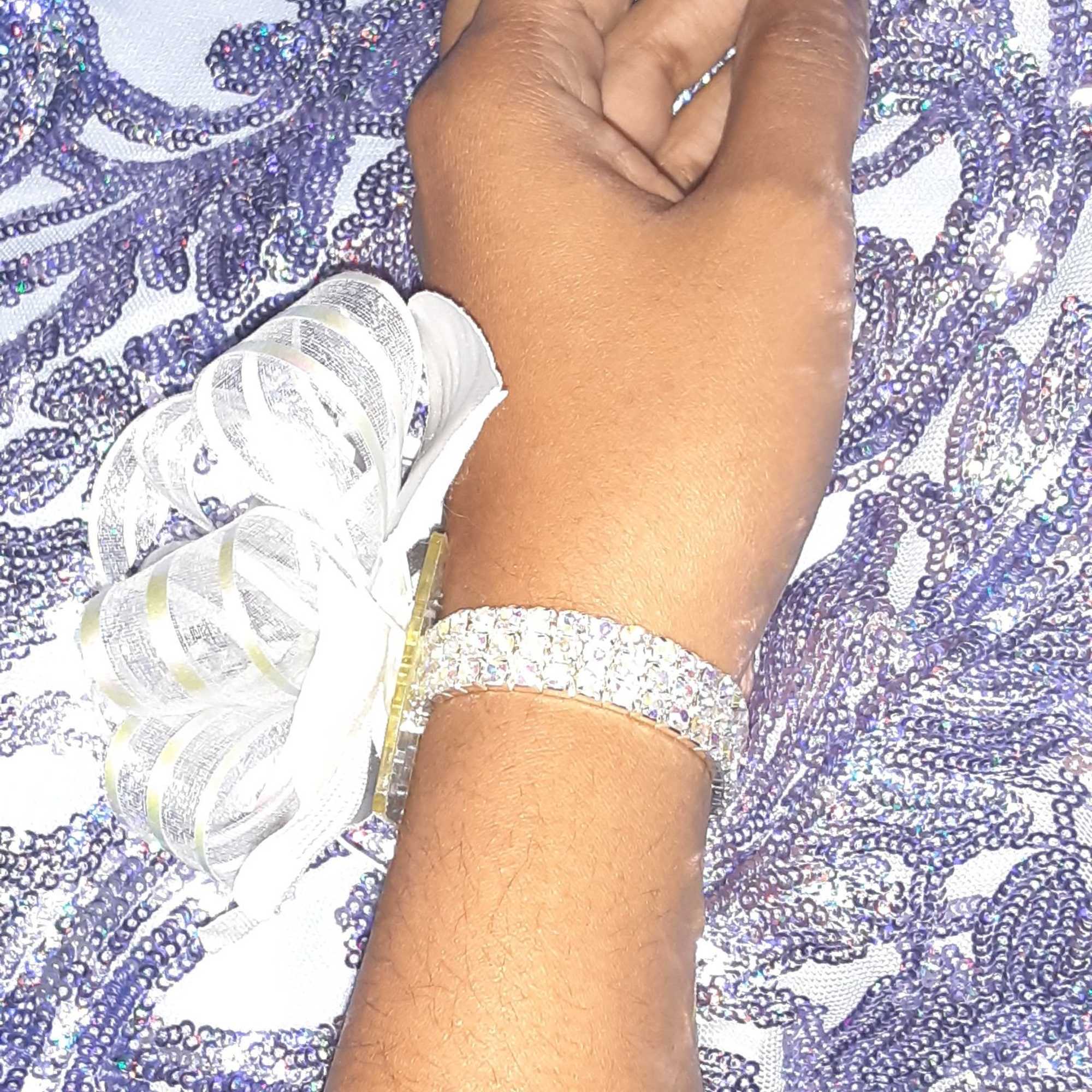 Iridescent pearl pull bow ribbon with silver base; secured on wrist by