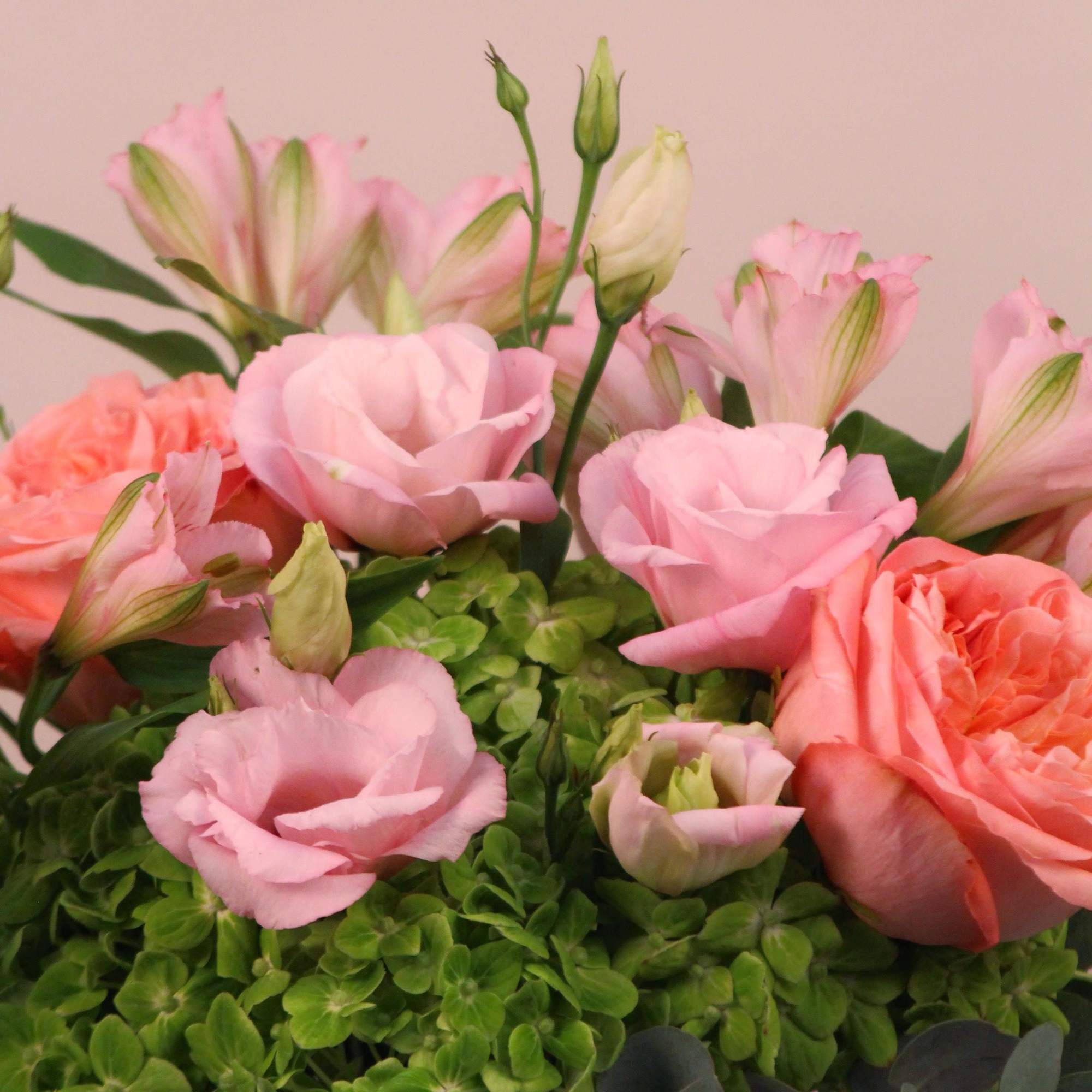 A lush arrangement of hydrangeas, garden roses, lisianthus, alstromeria and eucalyptus in