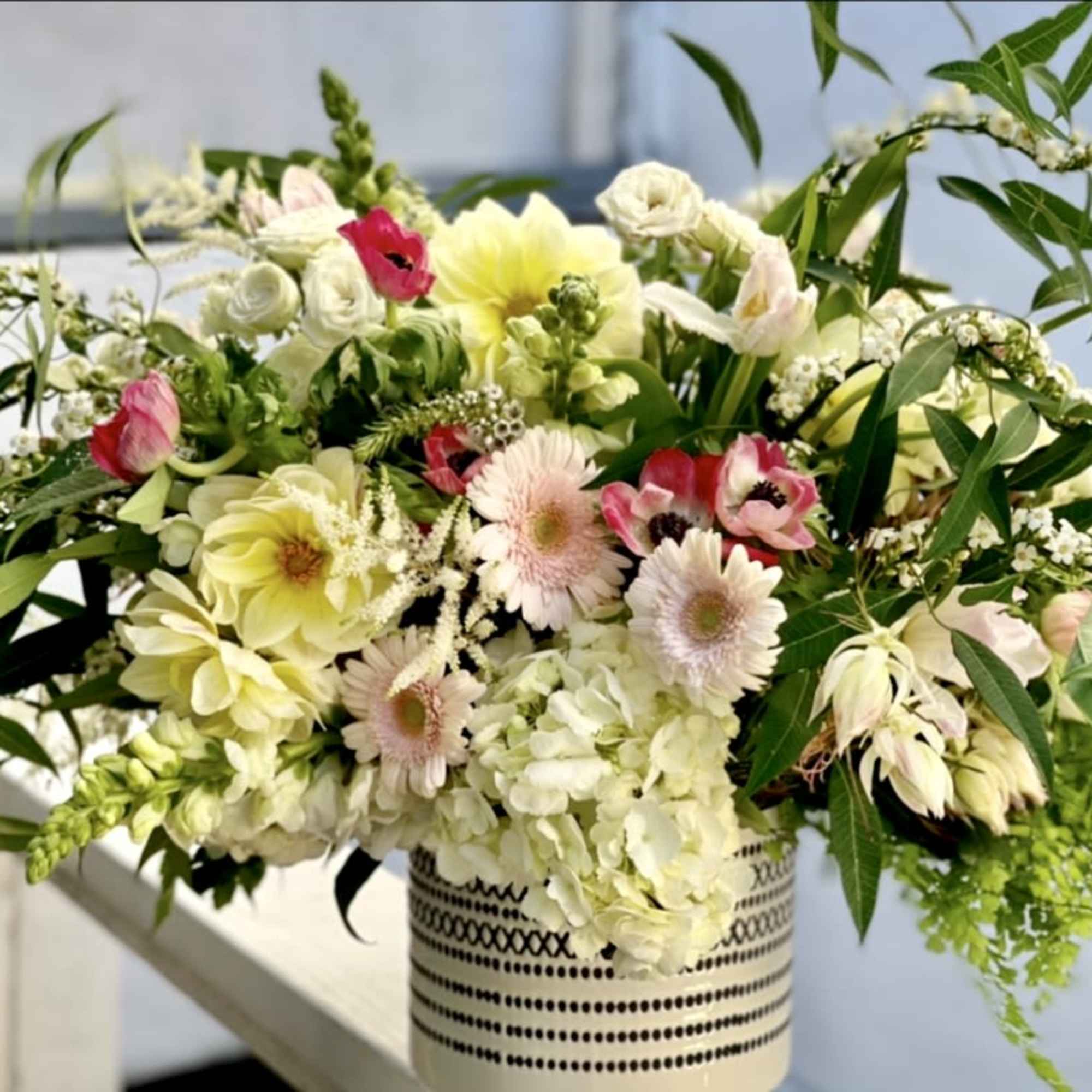 A romantic and fun design filled with gerber daisies, roses, anemones, dahliassnapdragonshydrangeas