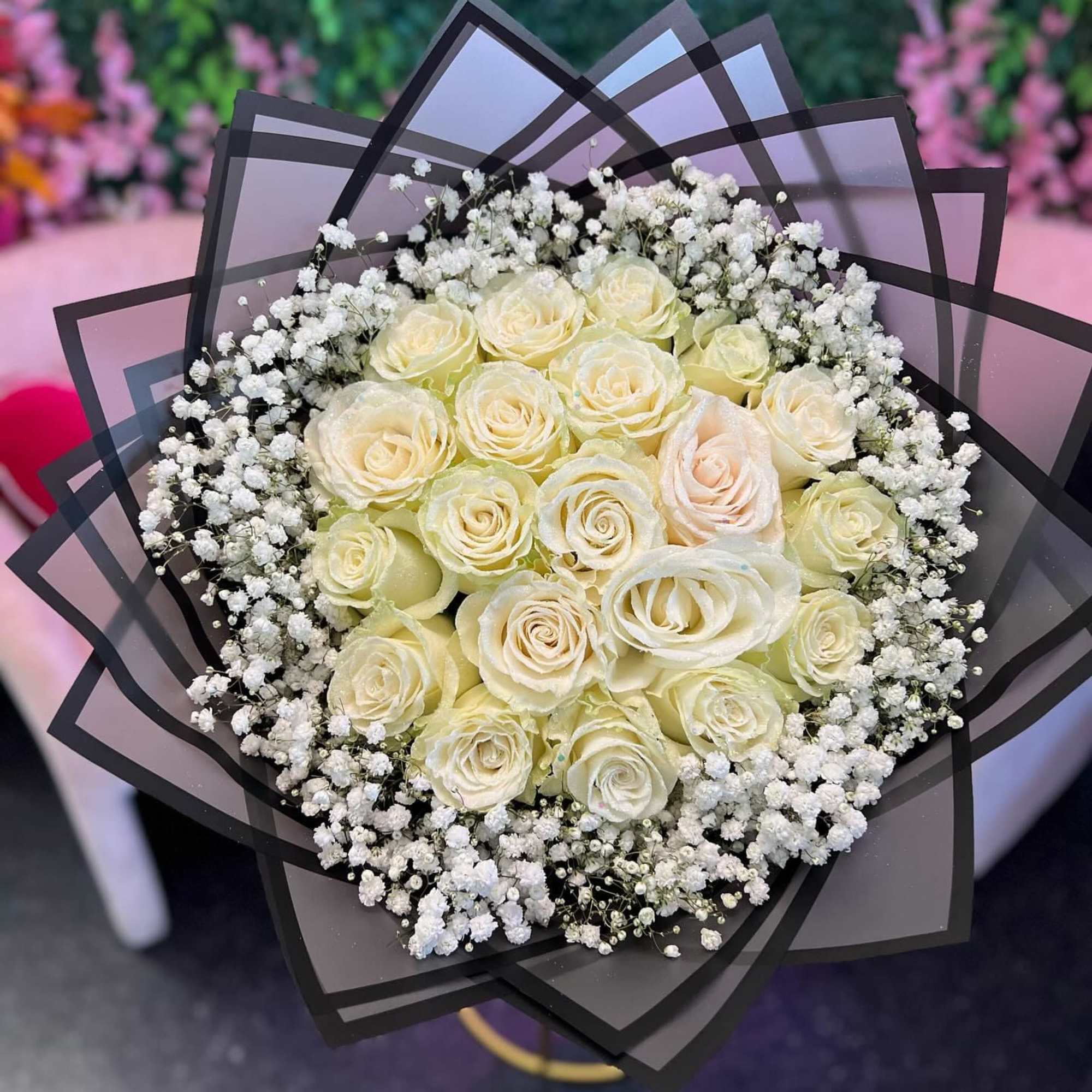 The bouquet is a captivating blend of pristine white roses and delicate