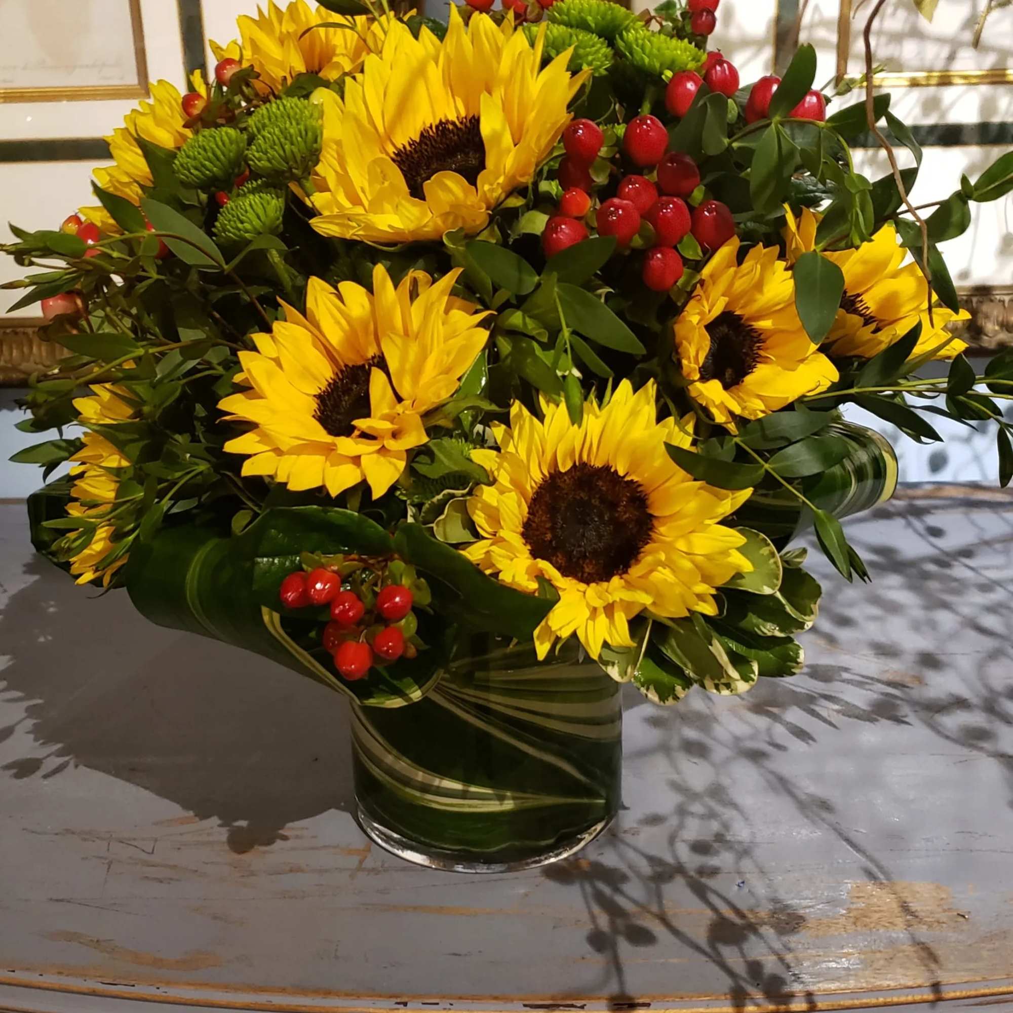 An elegant gathering vase filled with 20 seasonal bright sunflowers and &amp;
