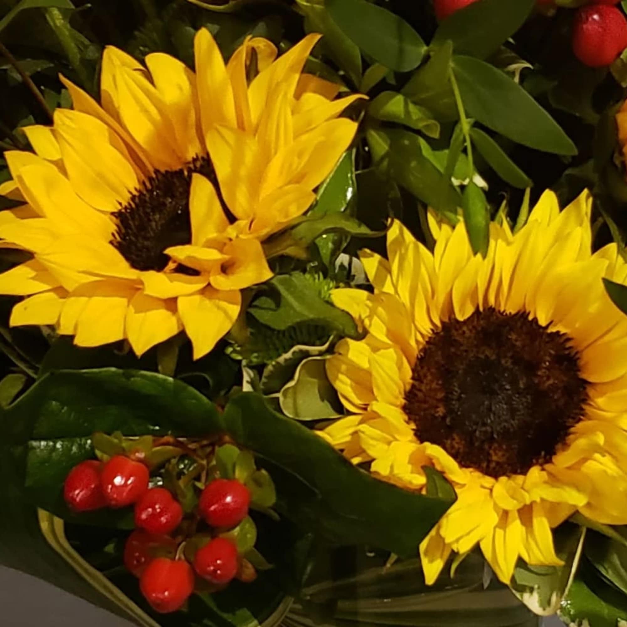 An elegant gathering vase filled with 20 seasonal bright sunflowers and &amp;