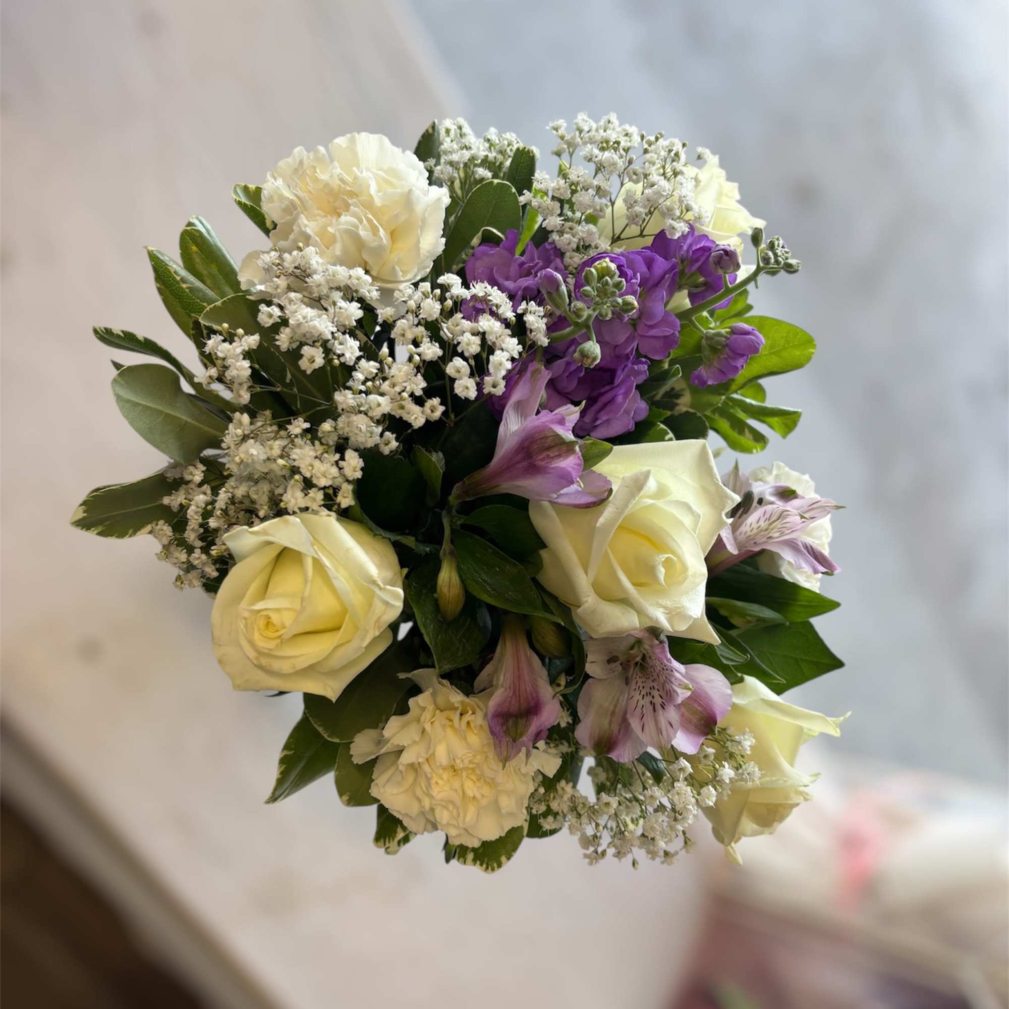 Arrangement with white roses and carnations; lavender alstroemerias and stock; accented with Arrangement with white roses and carnations; lavender alstroemerias and stock; accented with