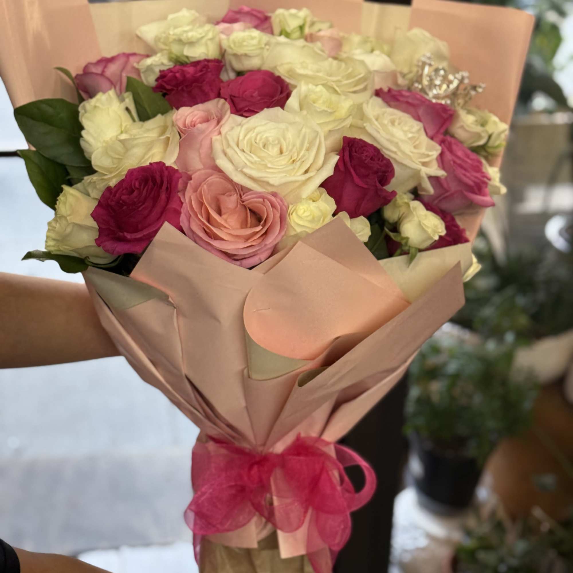 This bouquet with soft blush, deep fuchsia, and creamy white roses paired