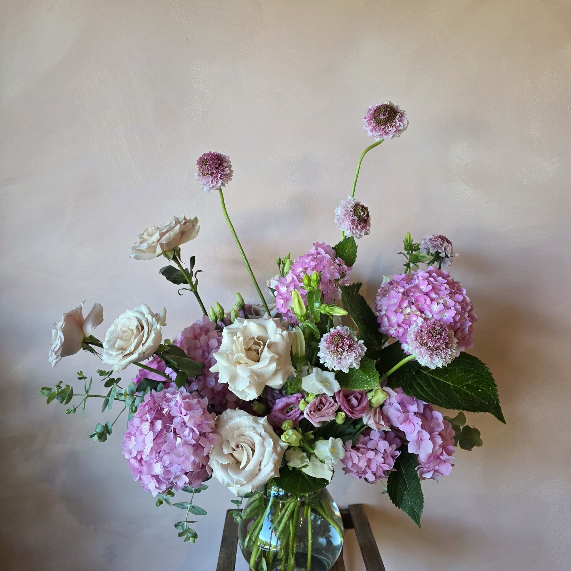 This arrangement delivers a harmonious blend of hydrangeas, roses, and other blooms